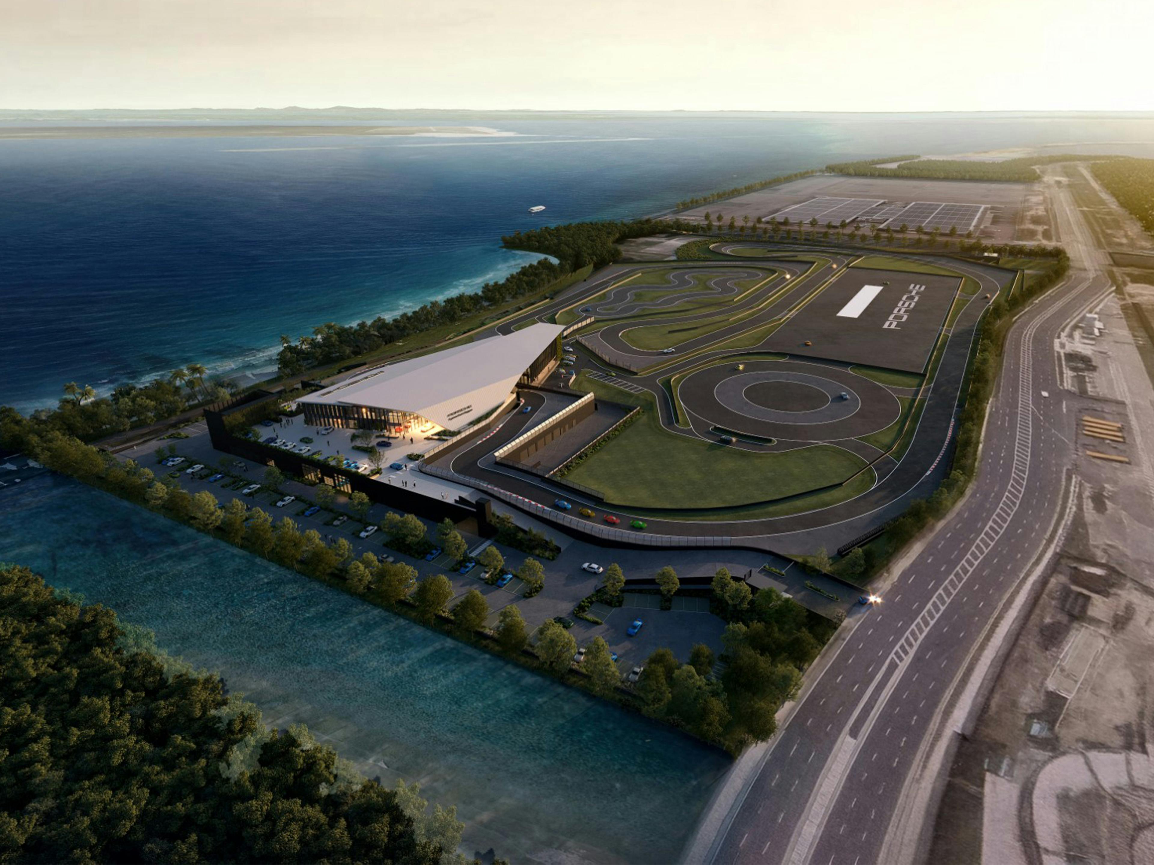 Vista aérea del Porsche Experience Center Singapore con circuito de conducción a lo largo de la costa.