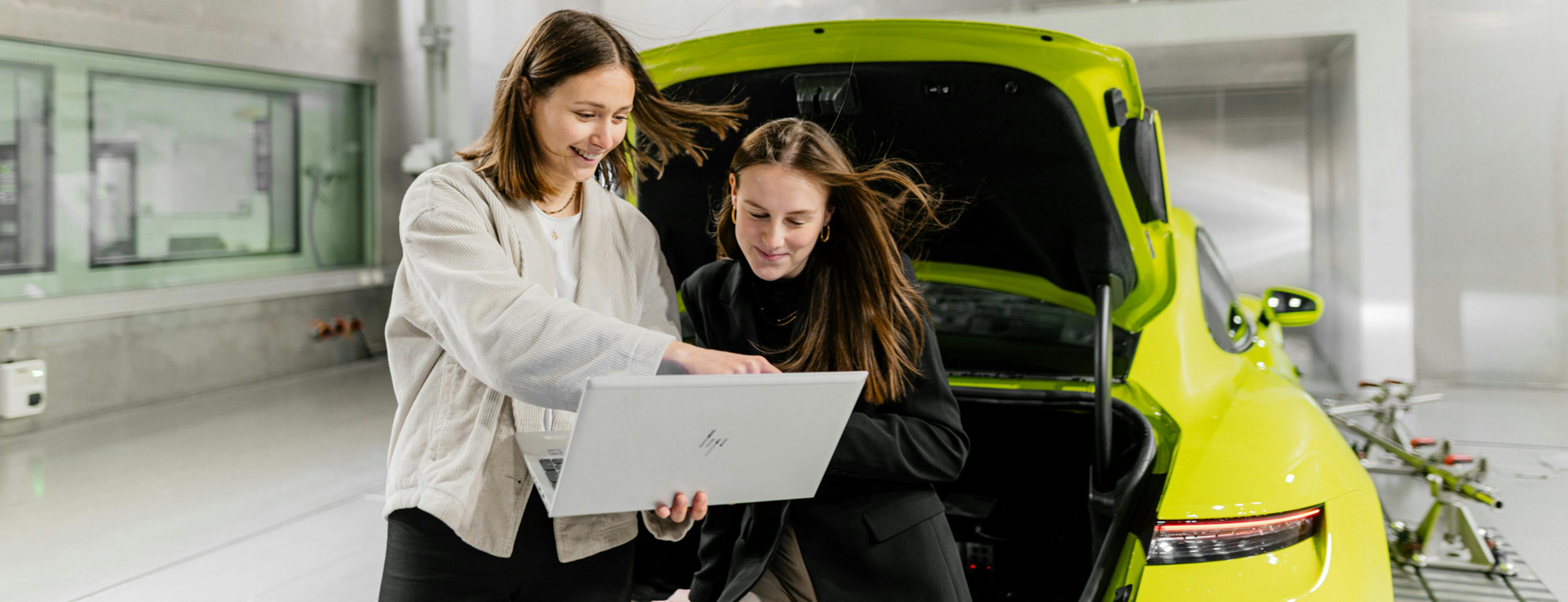 Dual-Studenten der Mechatronik untersuchen ein Porsche-Modell.