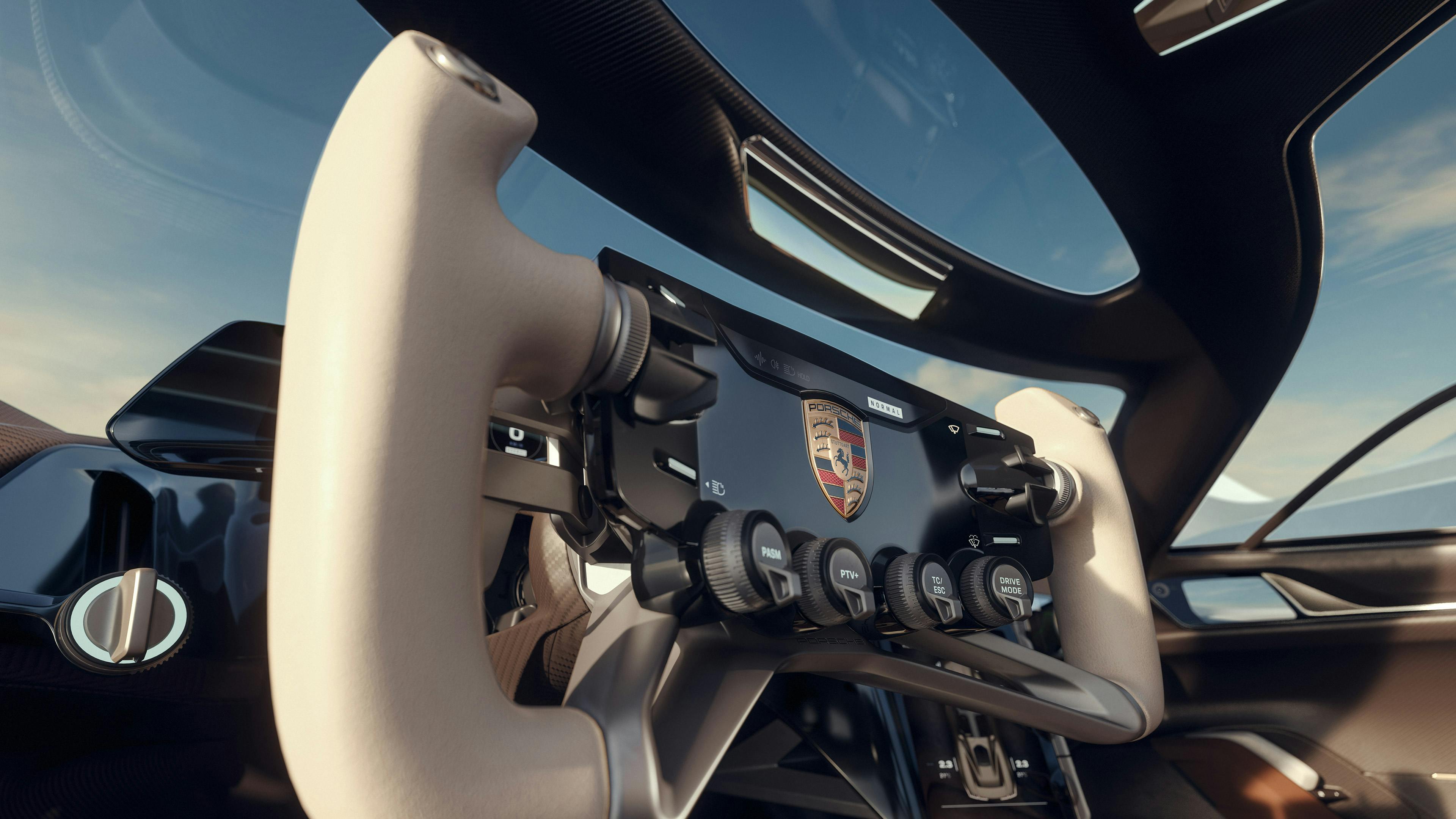 Habitacle de la Porsche Mission X : vue du volant ouvert en partie haute avec sélecteurs de mode et poignées recouvertes de cuir.