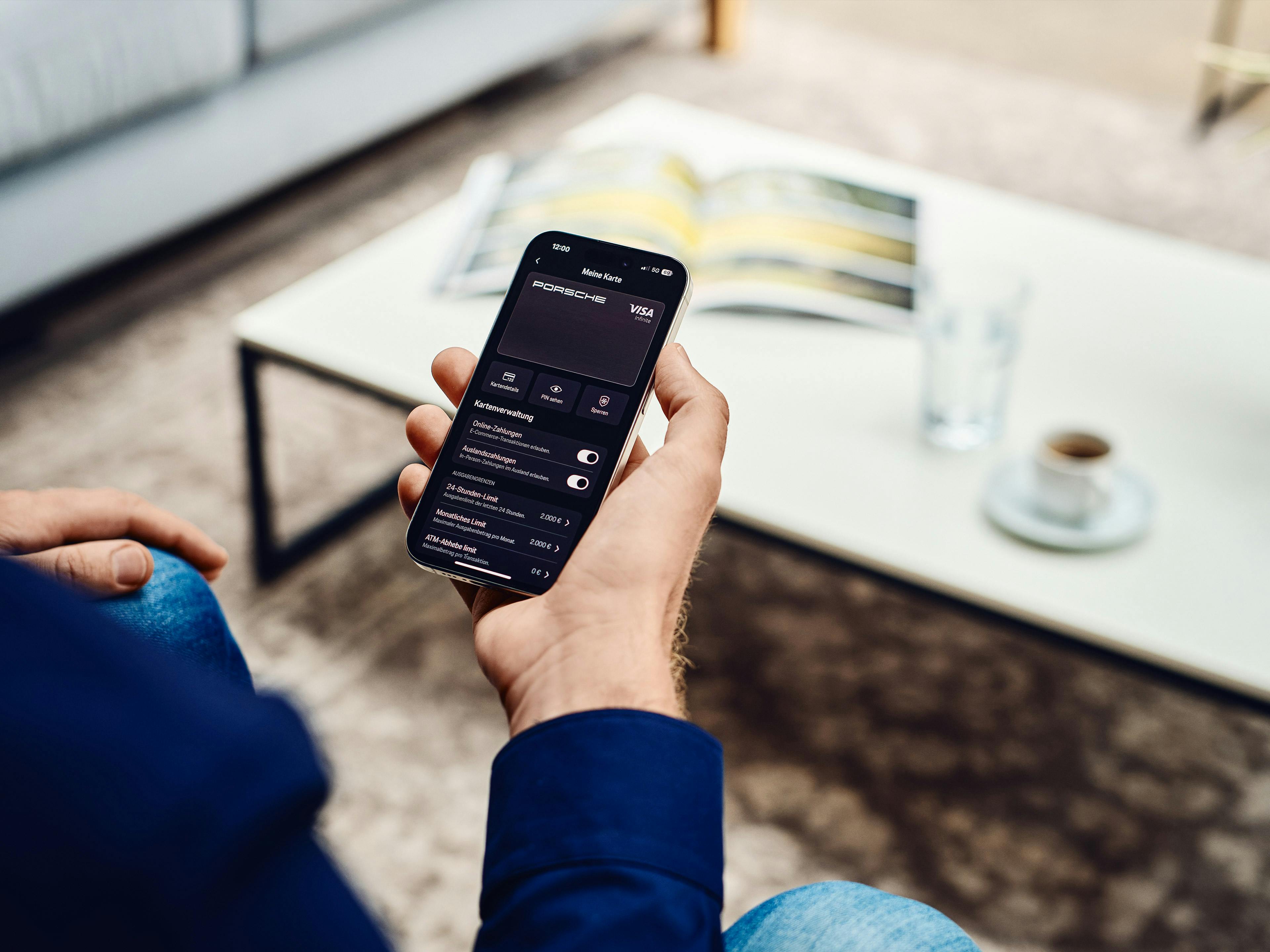 Ein Mann prüft in der My Porsche App seine Transaktionen der Porsche Card.
