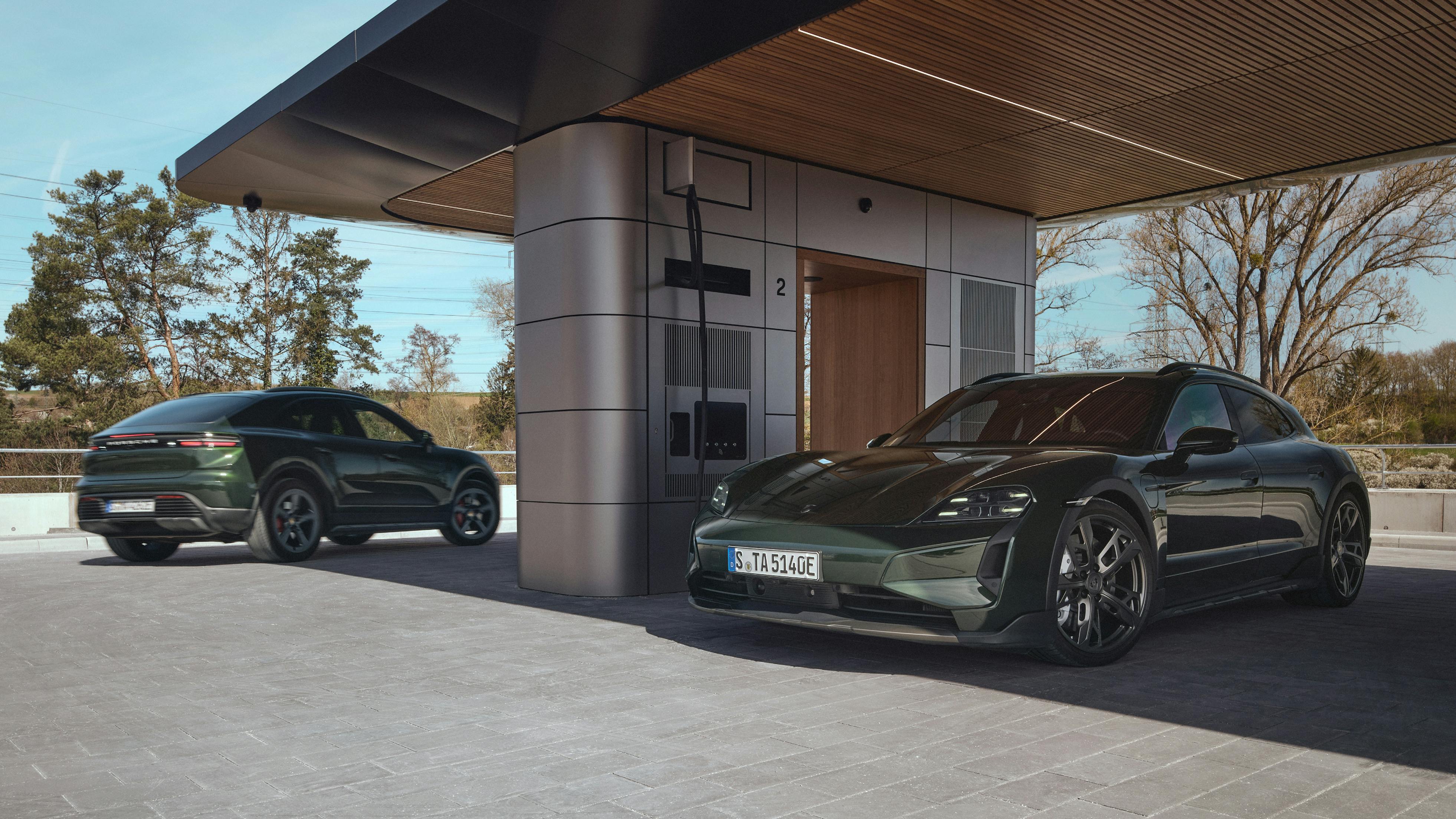 A Porsche Taycan Turbo Cross Turismo and a Porsche Macan 4S parked at a Porsche Charging Lounge.