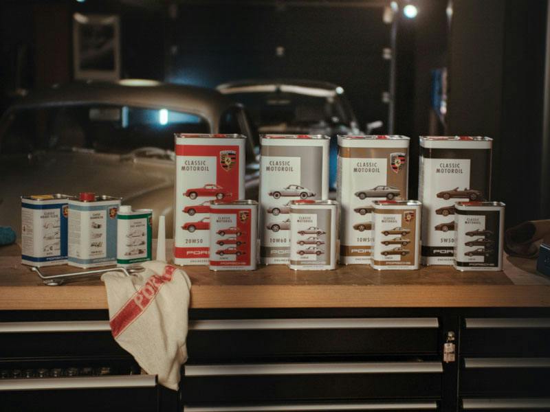Porsche Classic Motoroil cans standing on a table in a garage.