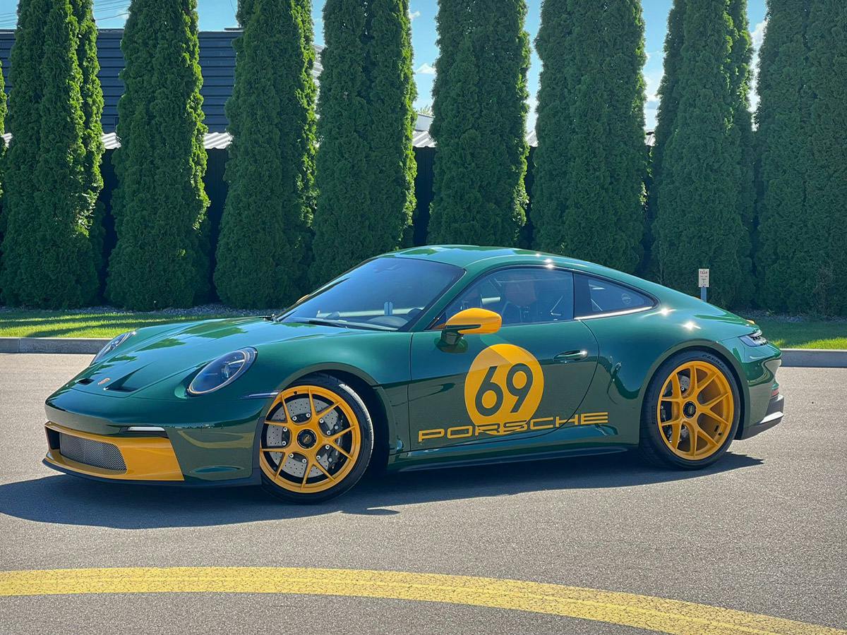 911 S/T in Paint to Sample colour Irishgreen with Signalyellow details, shown from the side in an outdoor setting.