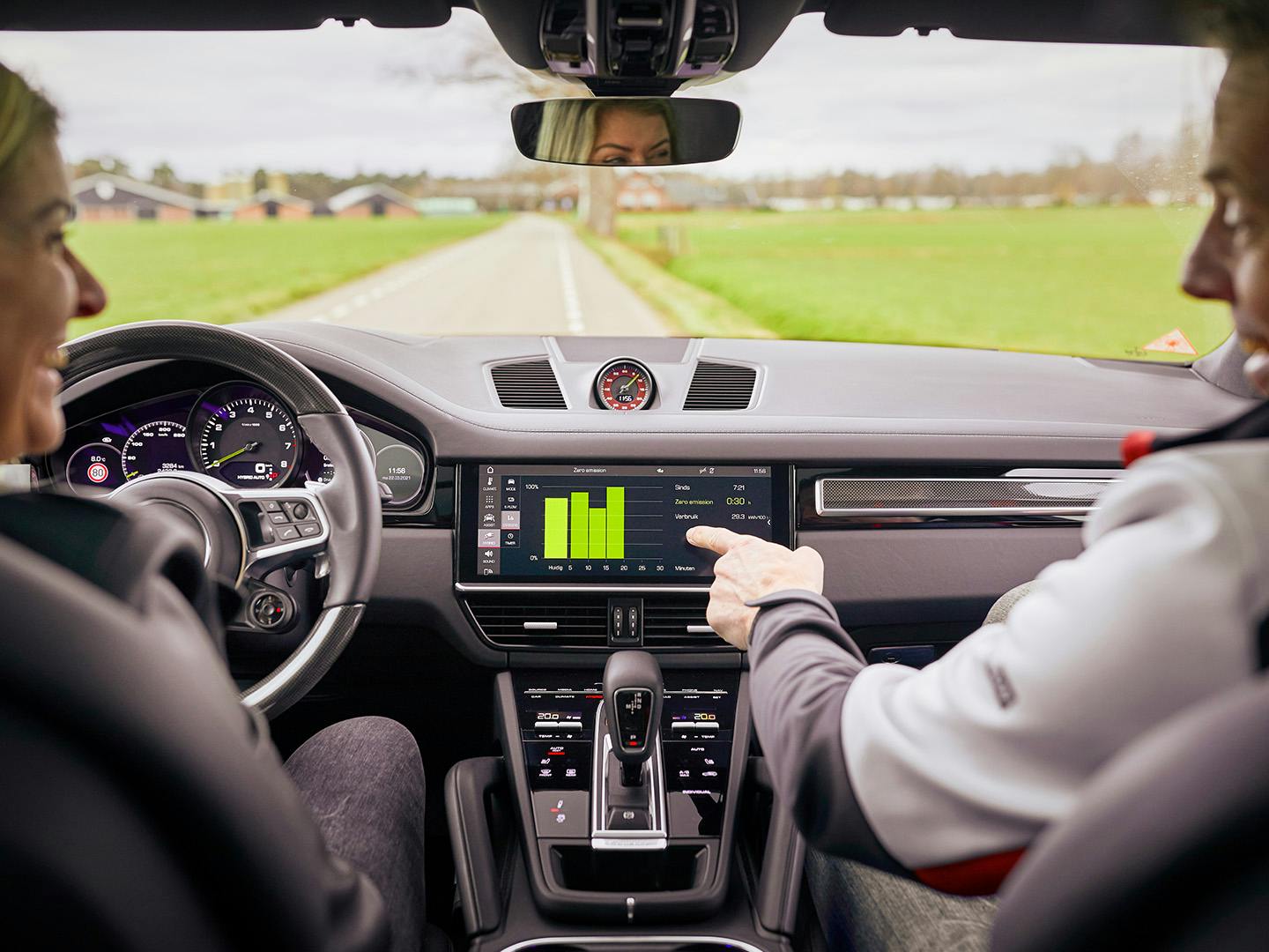 Twee mensen kijken tijdens een Porsche Advanced Driver Training op de digitale co-piloot