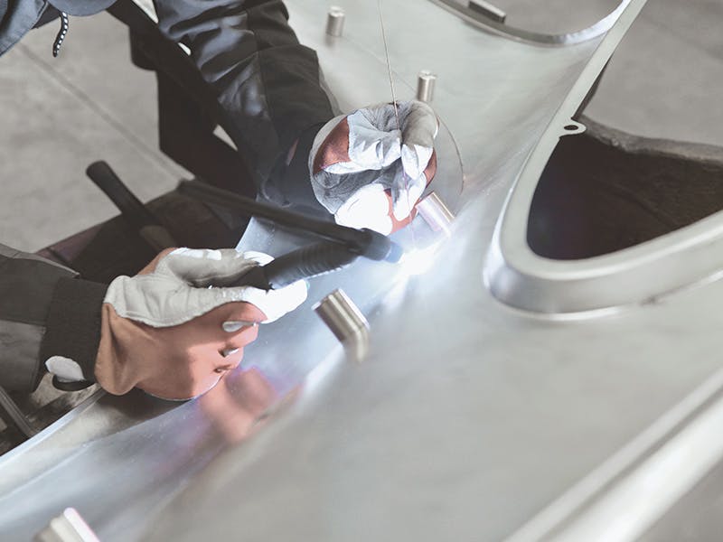 Detail shot: attaching the side panel and wing flares together, gloved hands