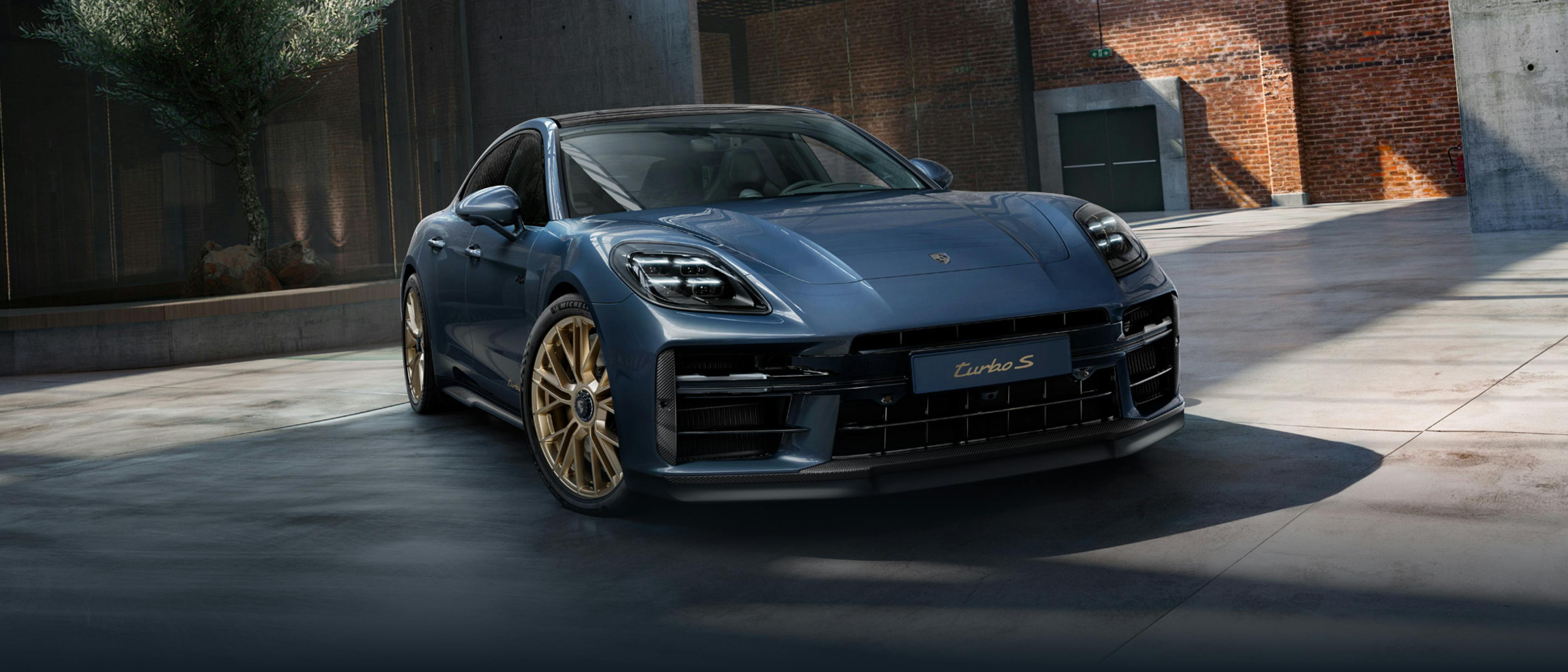 Front view of the front of the Porsche Exclusive Manufaktur Panamera Turbo S E-Hybrid in Yachting Blue Metallic with Aerokit Carbon.