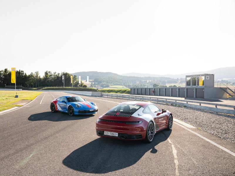 Une Porsche 911 rouge roule sur la piste du Porsche Driving Center de Lignières.