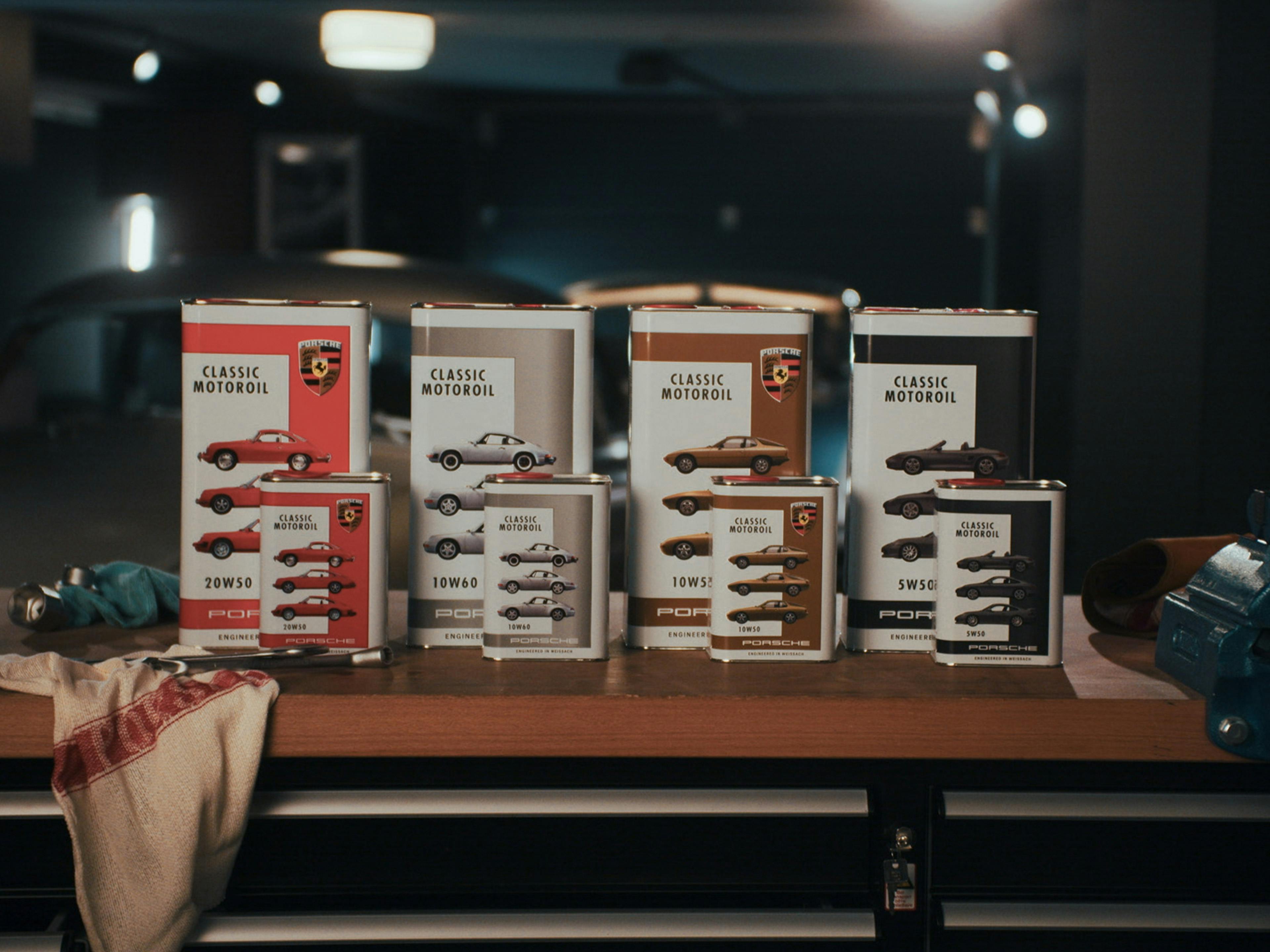 Pack shot of Porsche Classic Motoroils including machine cleaning cloth on a workbench in a garage.