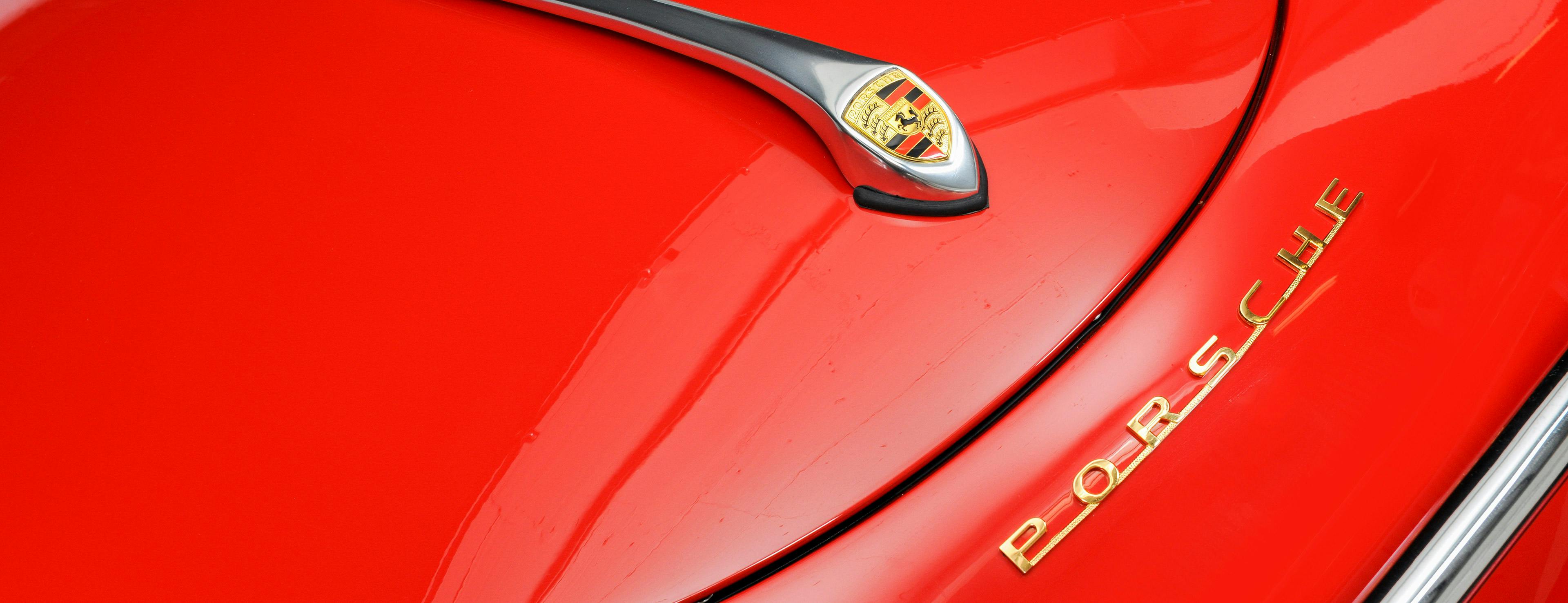 Roter Porsche 356 mit Porsche Wappen.