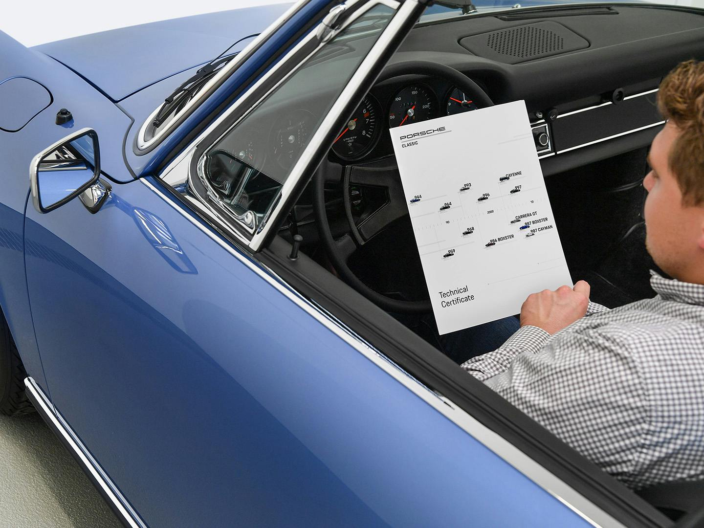 Een man bekijkt het Porsche Classic Technisch Certificaat in een Porsche klassieker