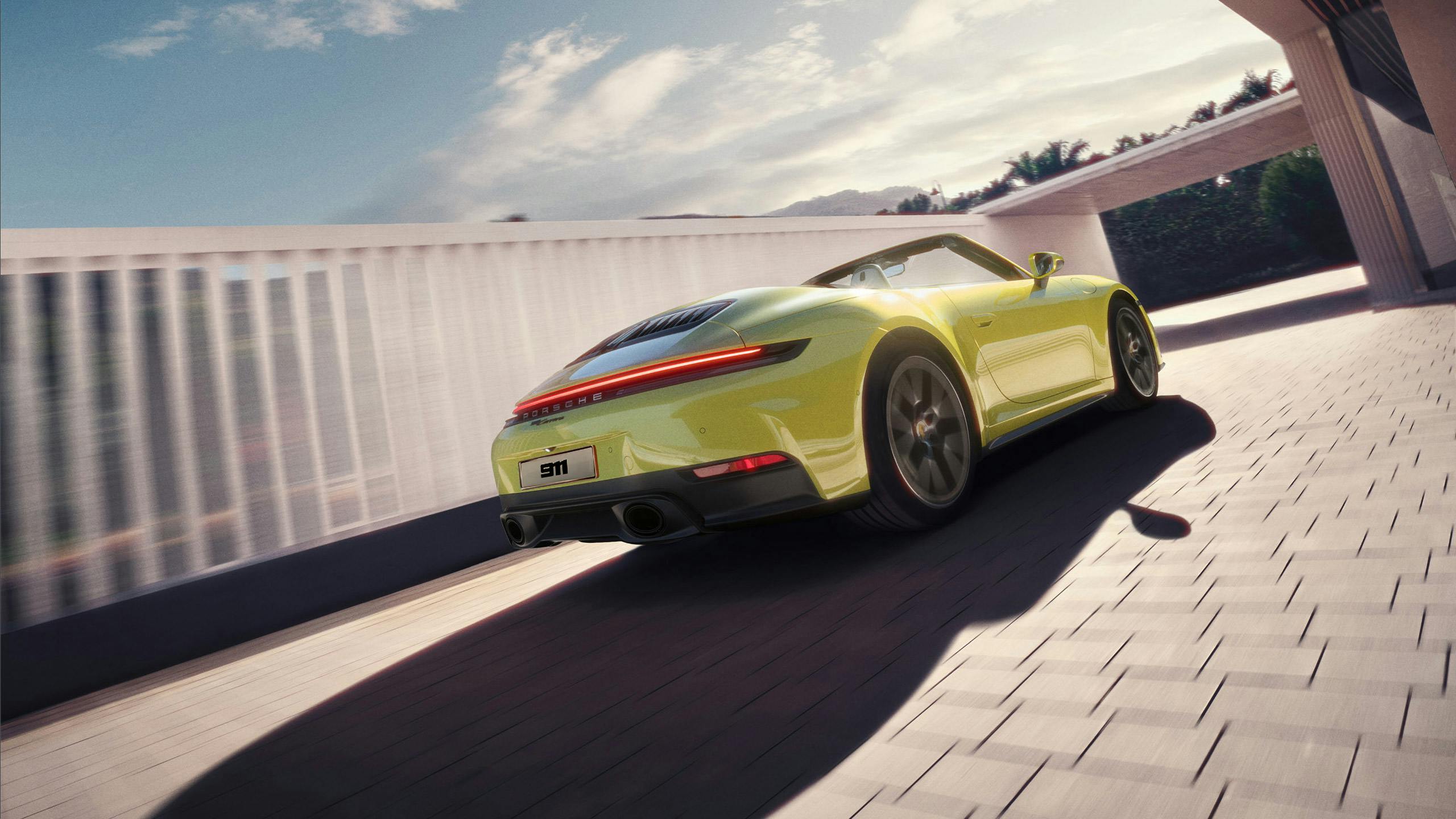 A lime green Porsche cabrio drives through a modern driveway, showcasing sleek design and rear LED lights under sunny skies.