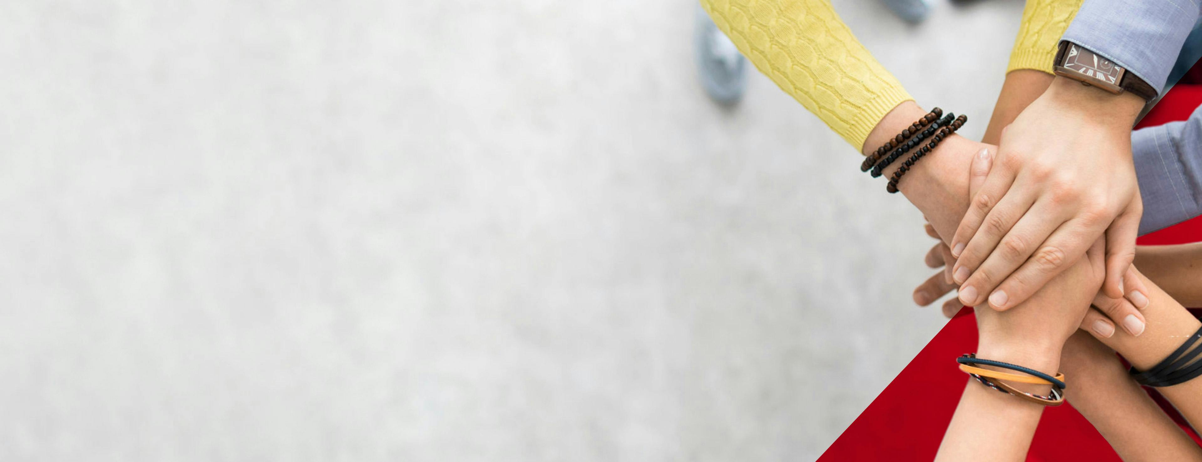 Business & Human Rights: Many hands of different people lying on top of each other.