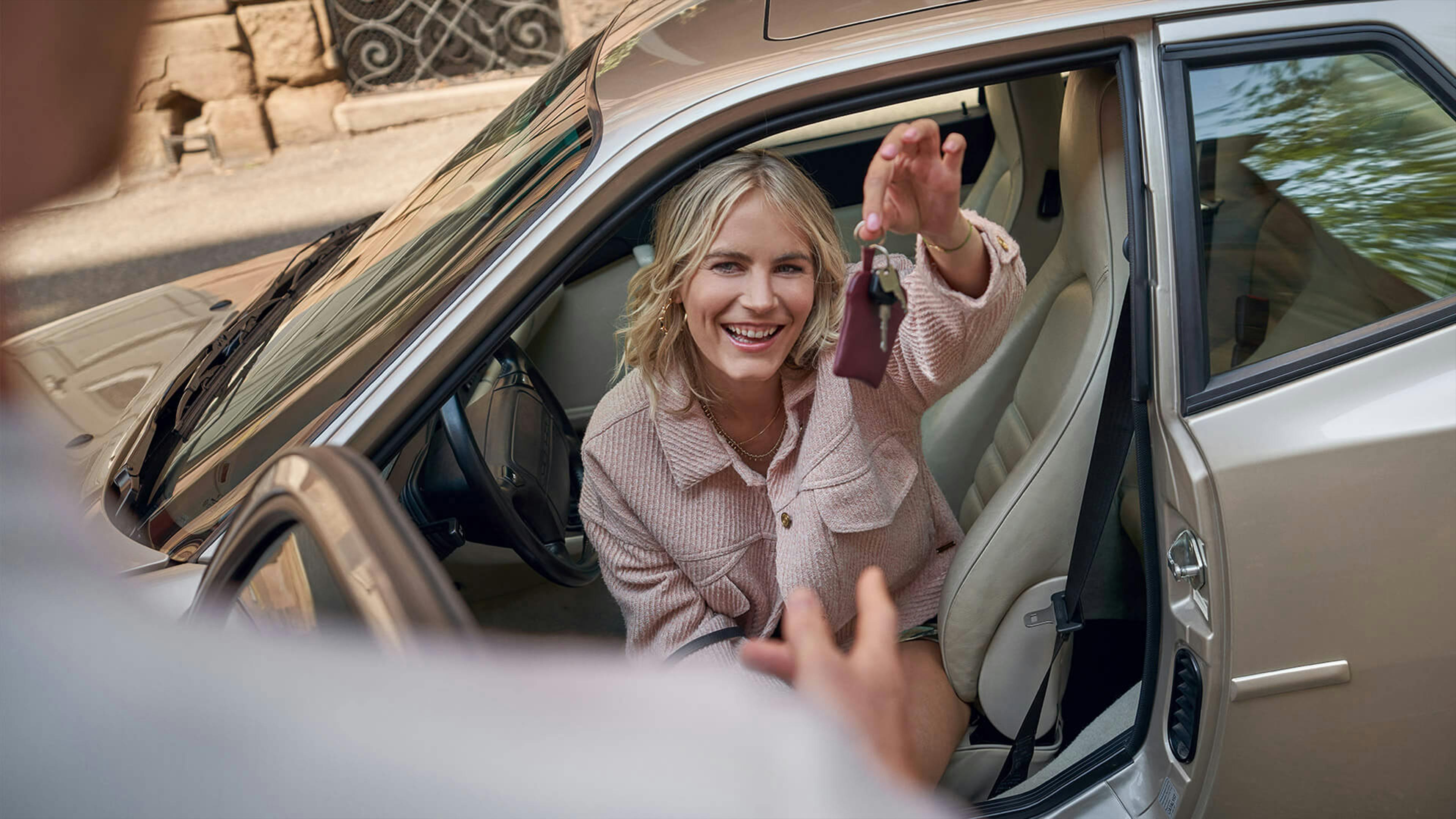 Woman sitting in a Porsche 944, holding up the car key