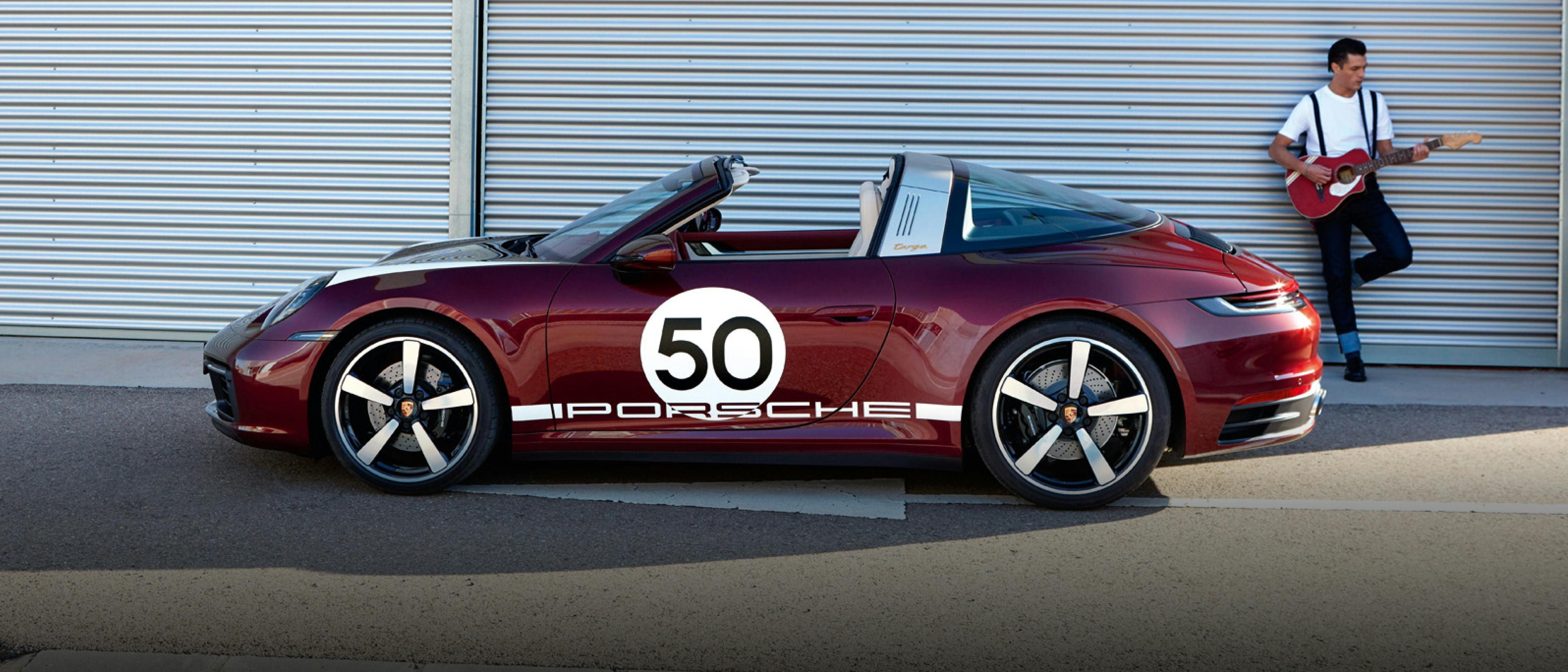 Porsche 911 Targa 4S Heritage Design Edition in Cherry Metallic. Side view. A man with a guitar is in the background.
