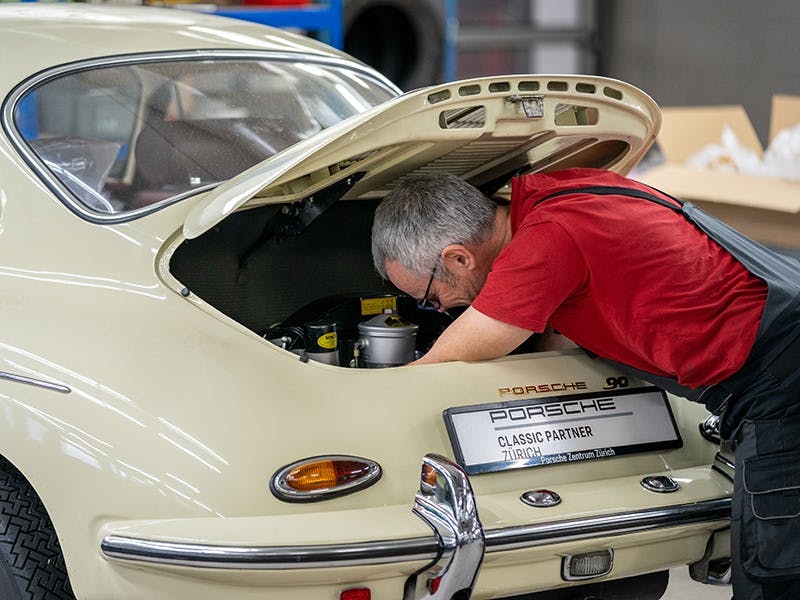 Meccanico del Centro Porsche Zurigo-Schlieren al lavoro su un'auto d'epoca.