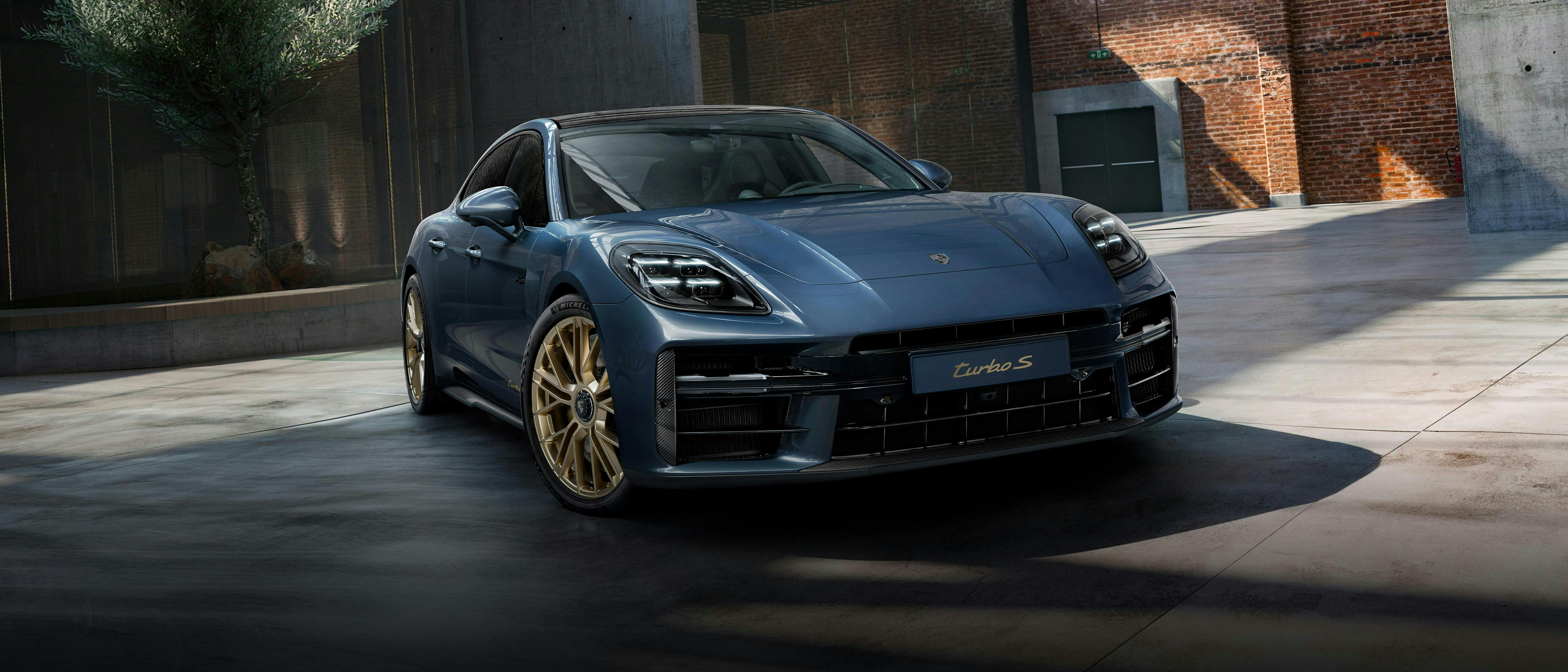 Front view of the front of the Porsche Exclusive Manufaktur Panamera Turbo S E-Hybrid in Yachting Blue Metallic with Aerokit Carbon.