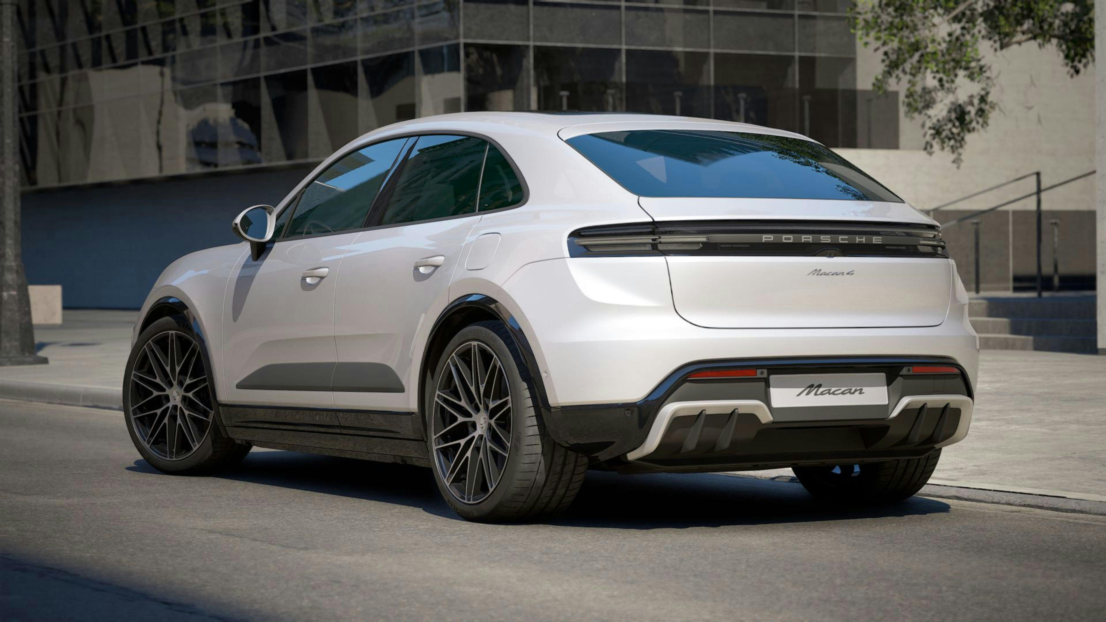 Vista posteriore di una Porsche Macan e-motion parcheggiata a bordo strada.