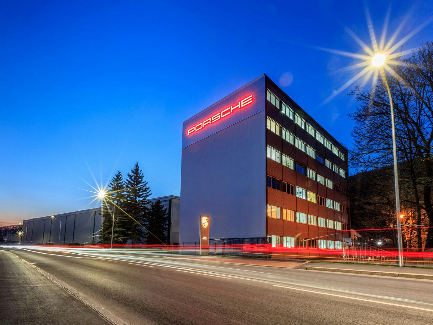 Building of Porsche Werkzeugbau Schwarzenberg with Red Porsche lettering on the building.