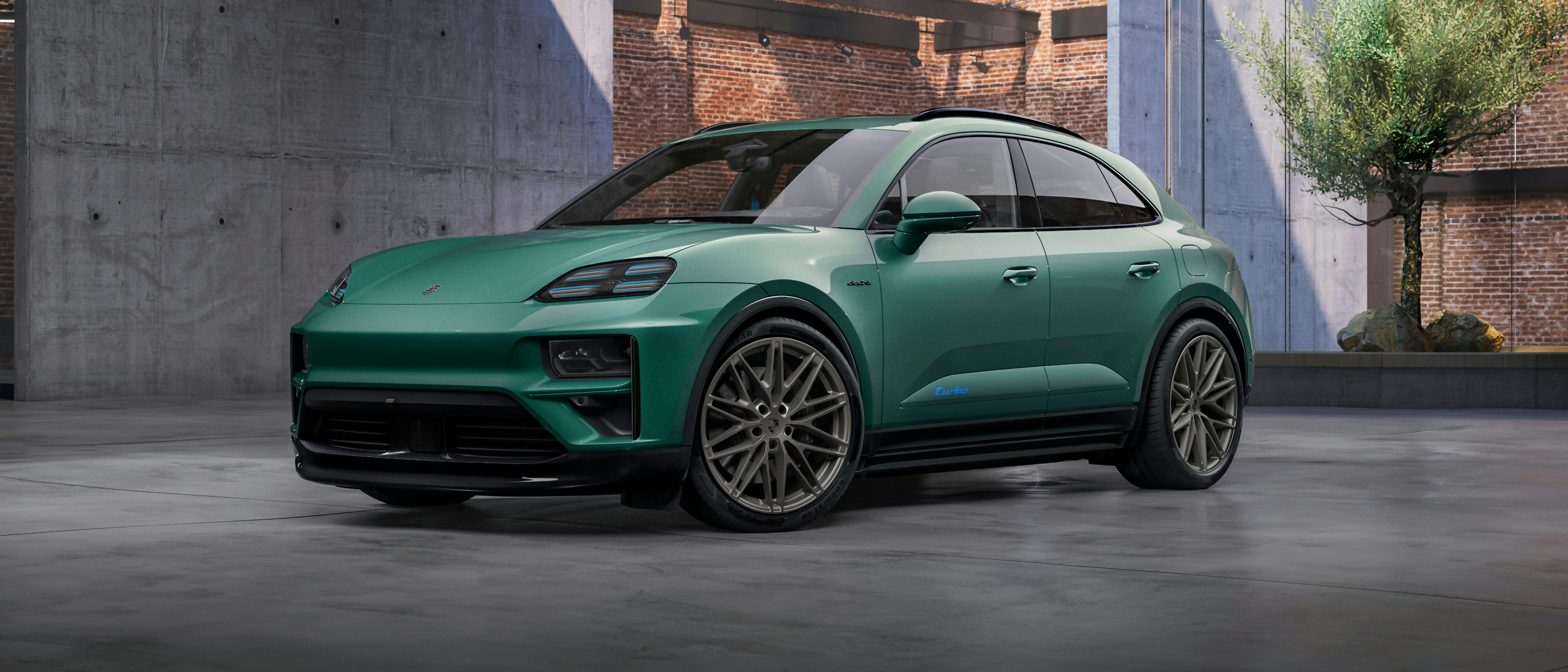 Un Macan Turbo Porsche Exclusive Manufaktur peint en Emerald Green Metallic dans un hall. Vue de côté.