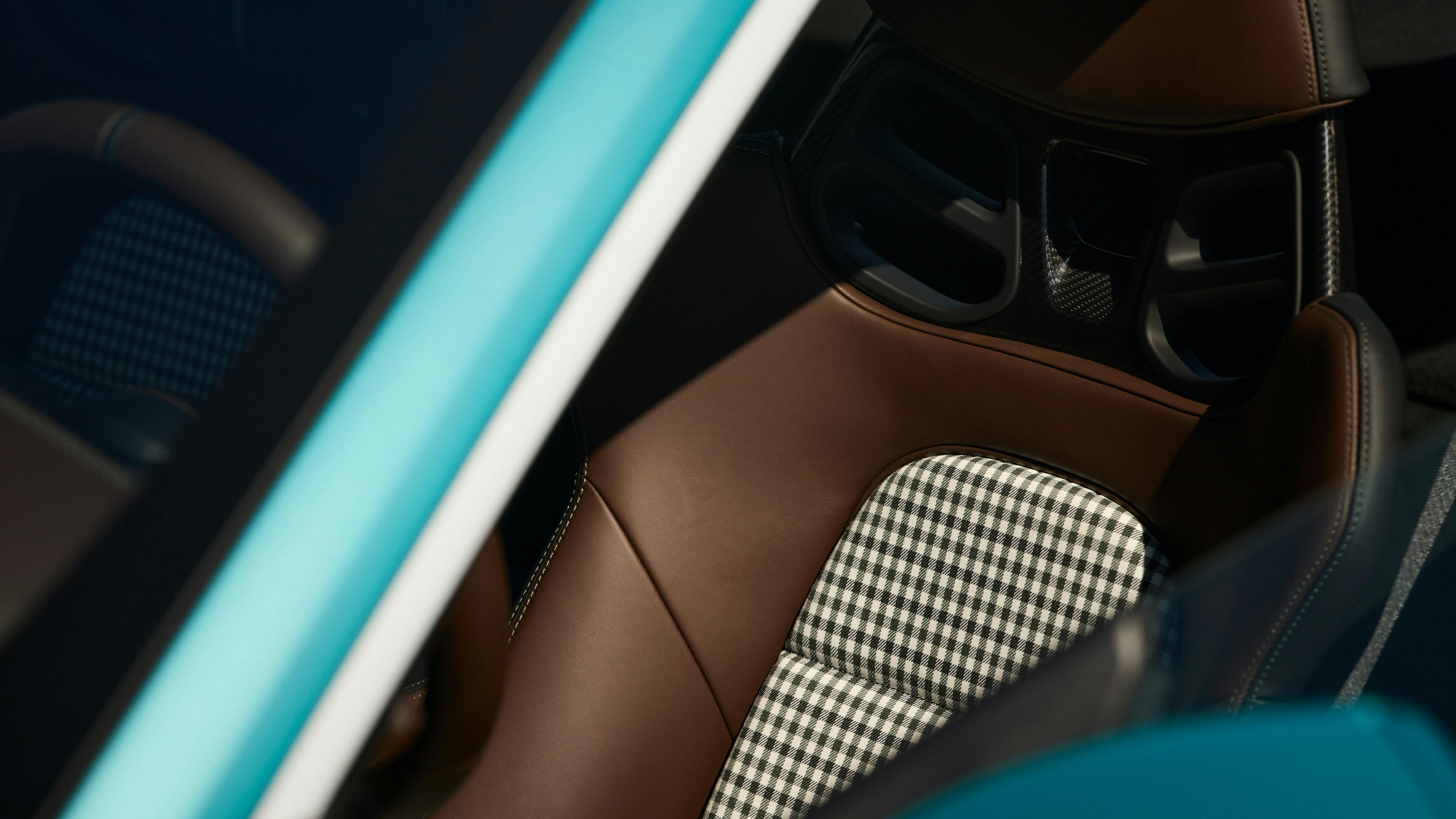 Detail of a Porsche 911 Carrera seat in brown leather with center section in classic black-and-white check pattern.