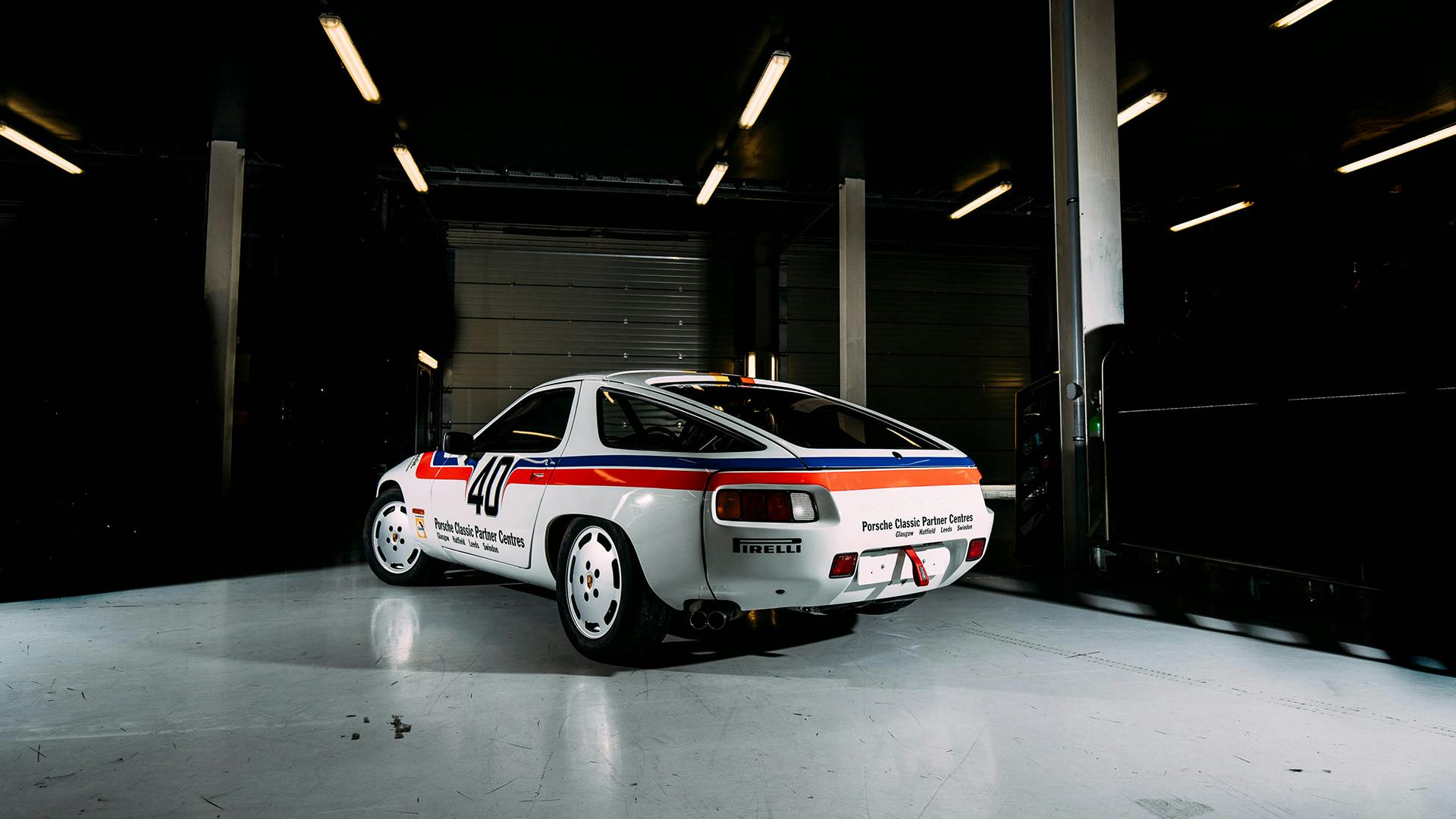 The Porsche 928 standing in a hall showing its rear.