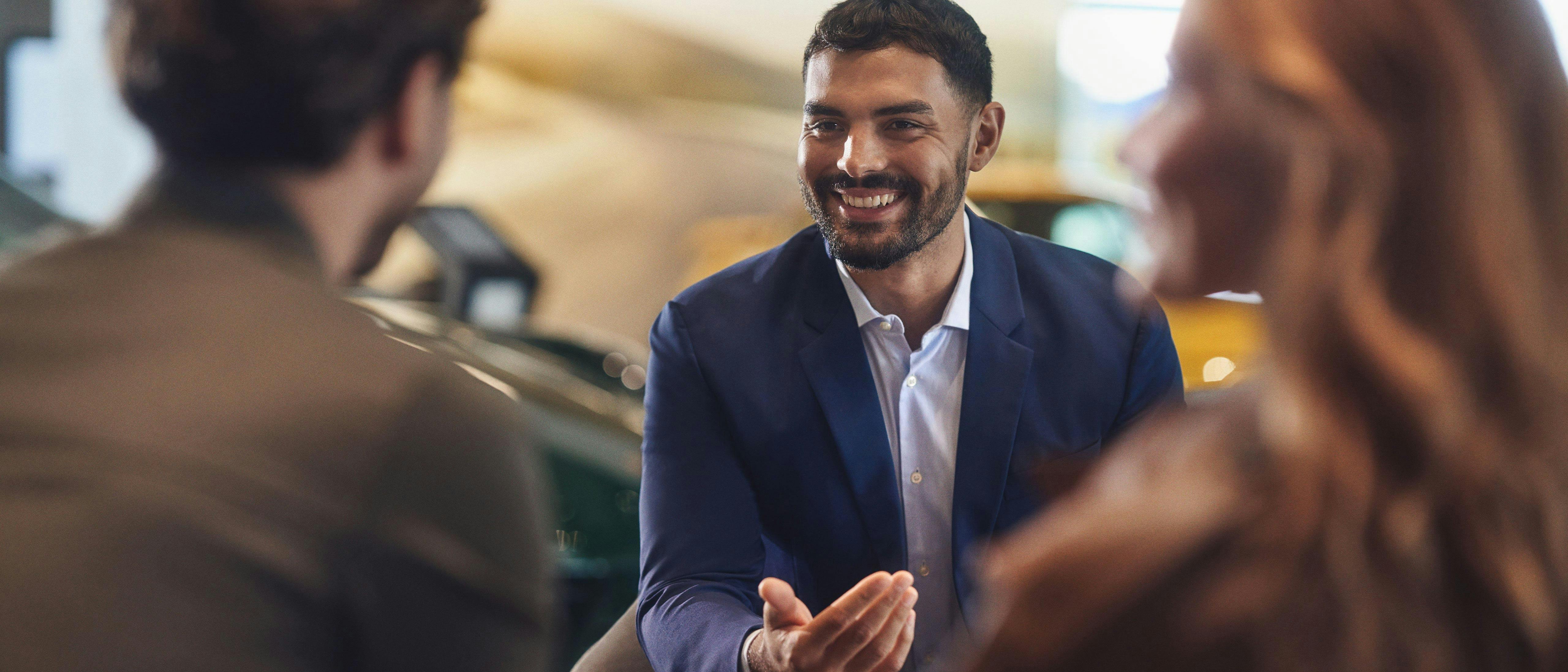 Smiling employee speaking to two customers