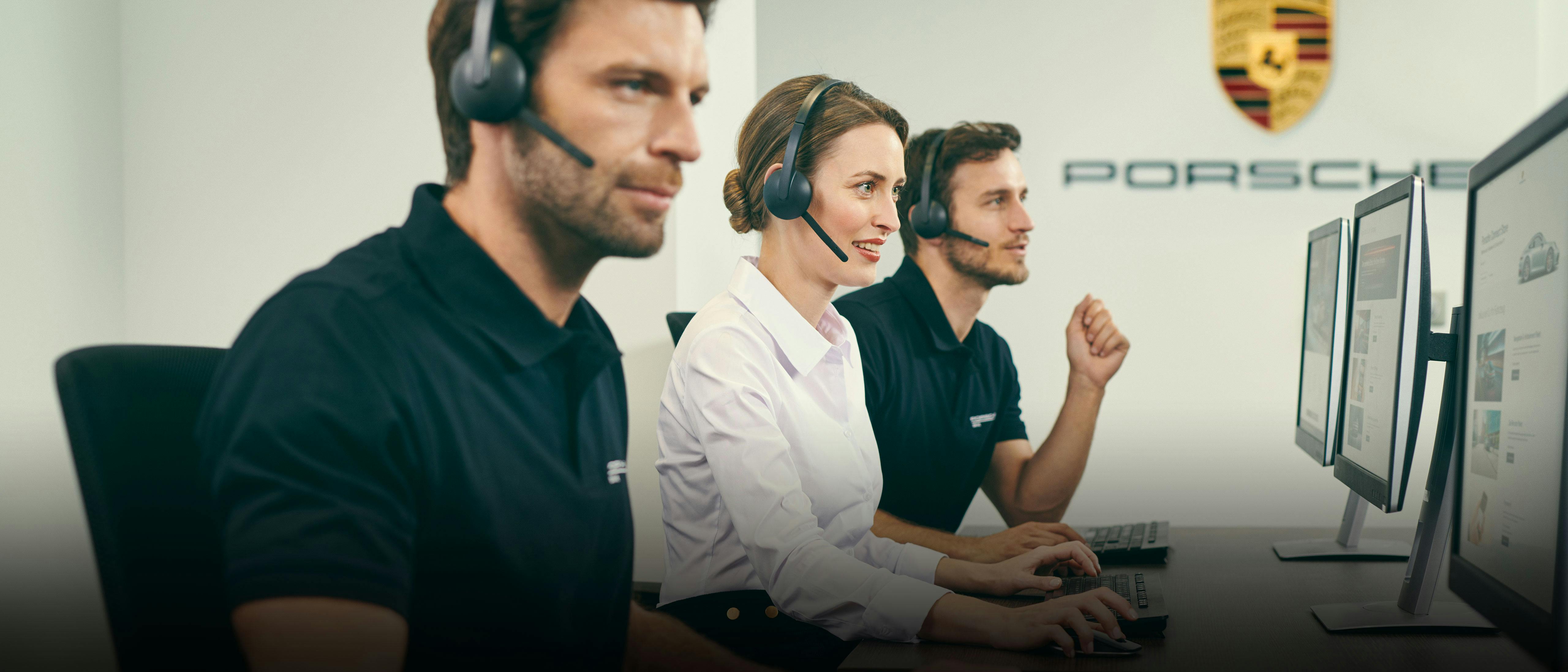 Due uomini e una donna del customer service Porsche lavorano davanti al computer