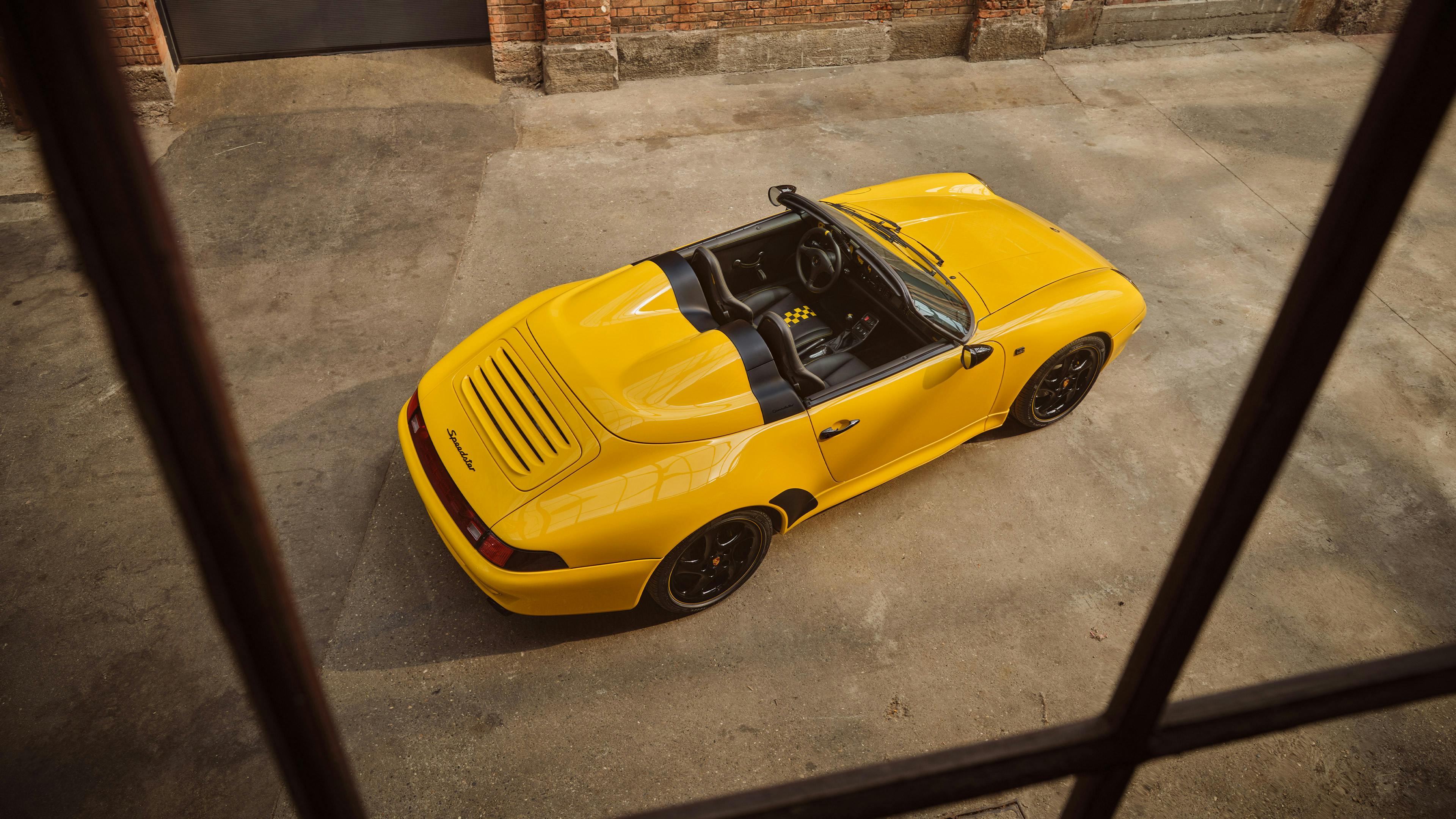 A 911 Speedster 993 in índividual colour Otto Yellow from above standing on concrete flooring.