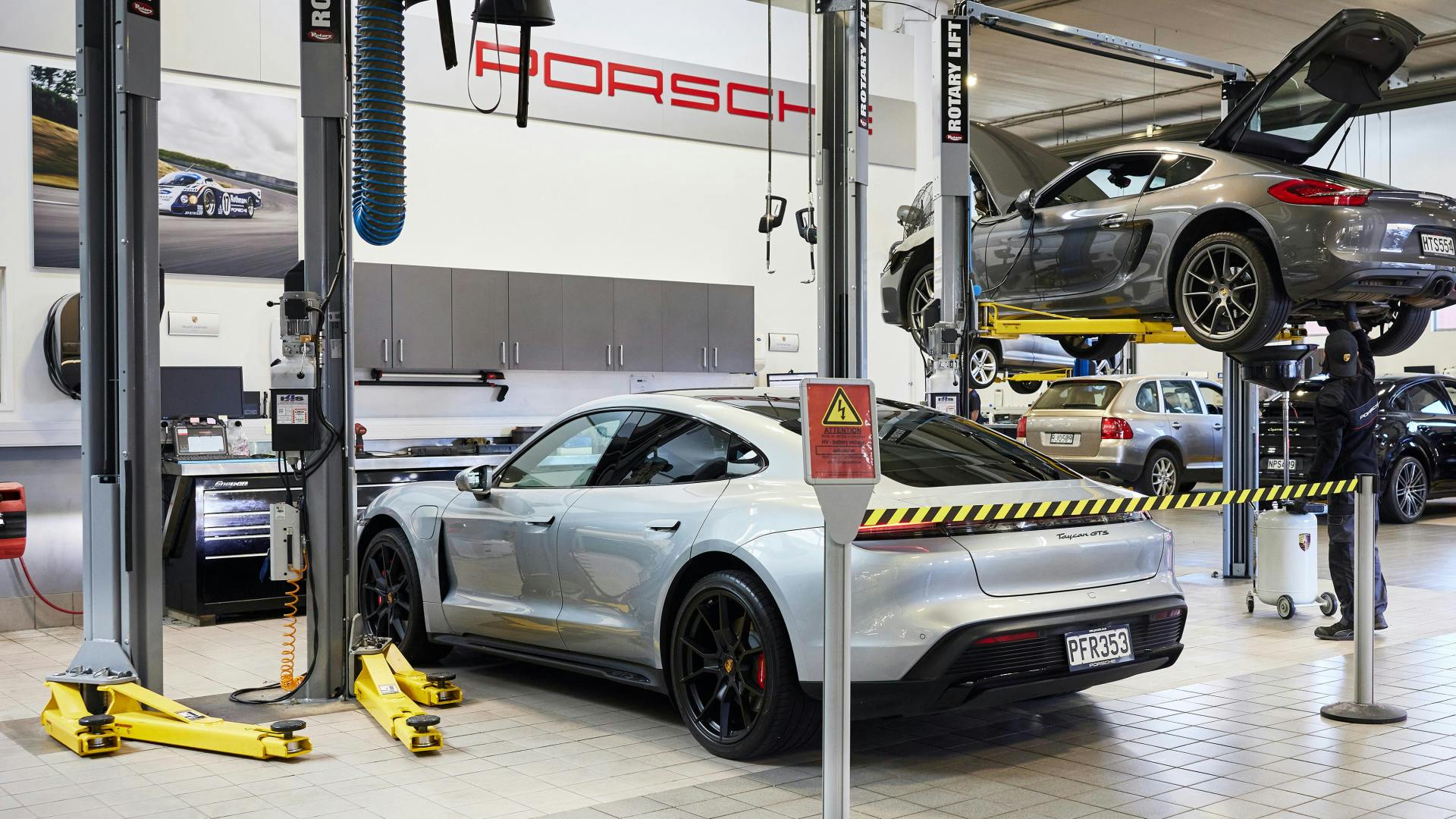 Porsche vehicles in workshop.