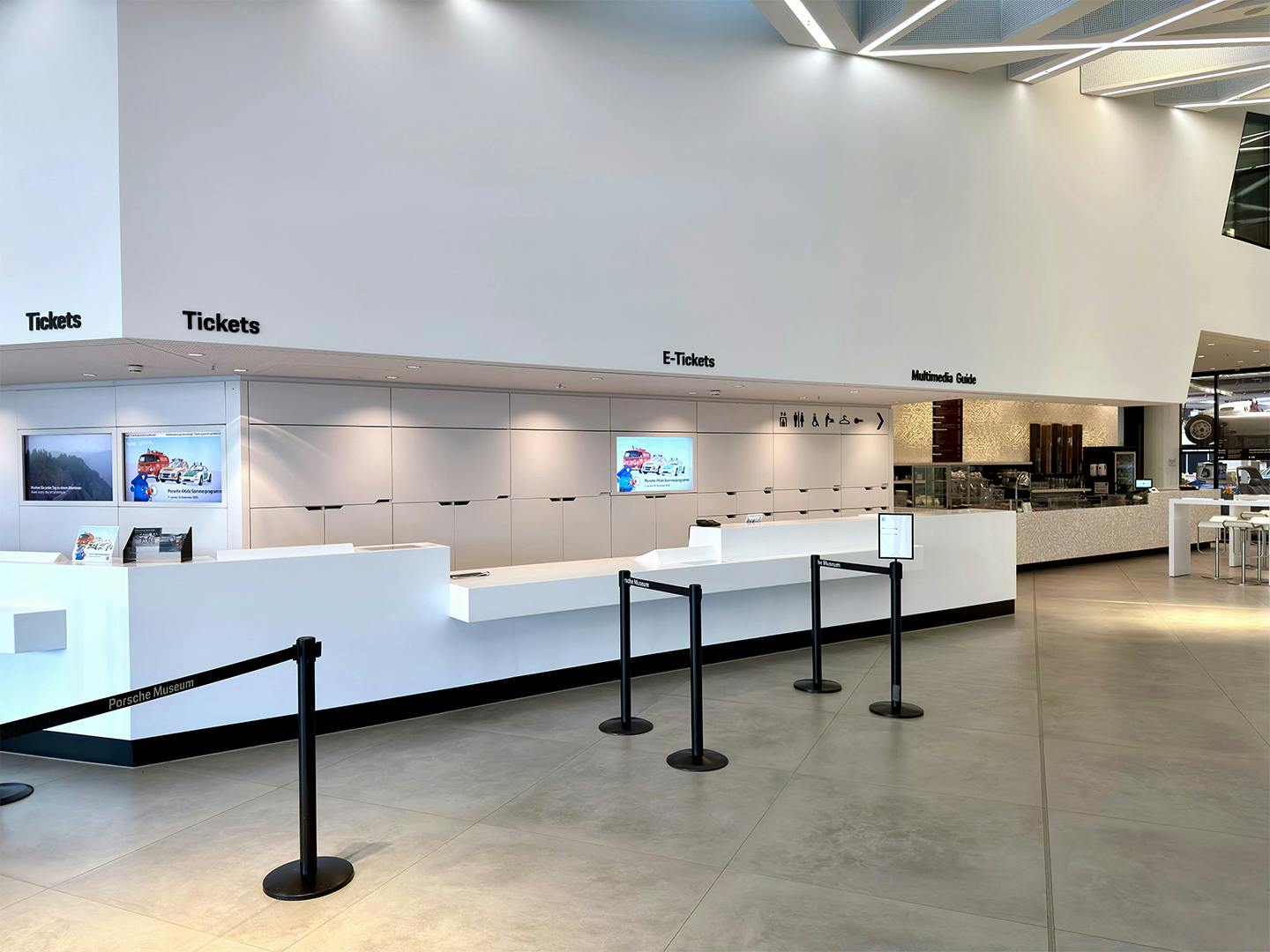 Moderne Ticketcounter-Zone mit Bereichen für „Tickets“, „E-Tickets“ und „Information Desk“, digitalen Bildschirmen und klarer Besucherführung.