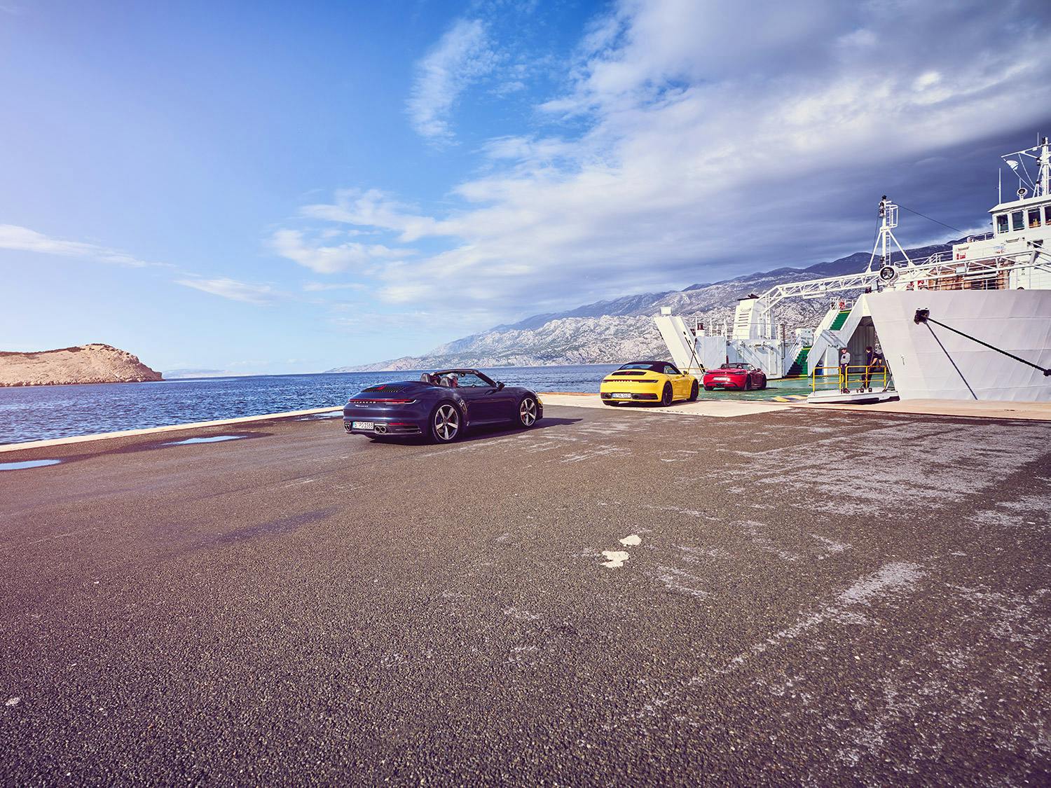 Deux Porsche aux couleurs vives amarrées dans un port.