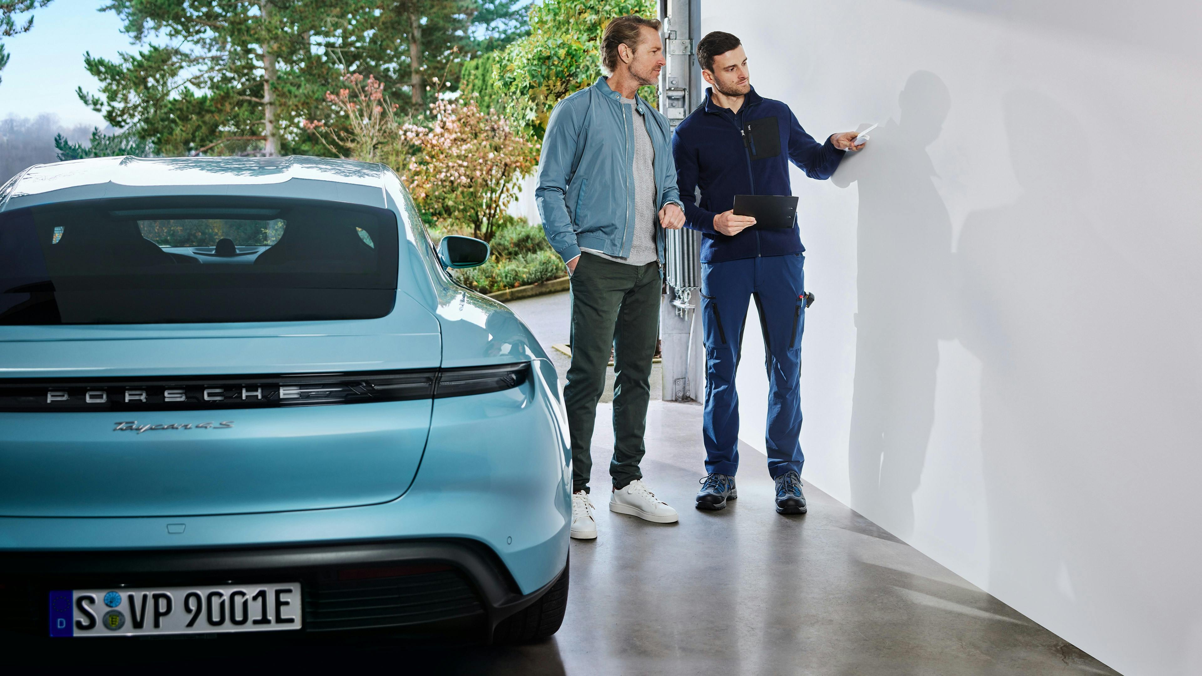 An electrician carries out the Porsche Home-Check at the customer's premises