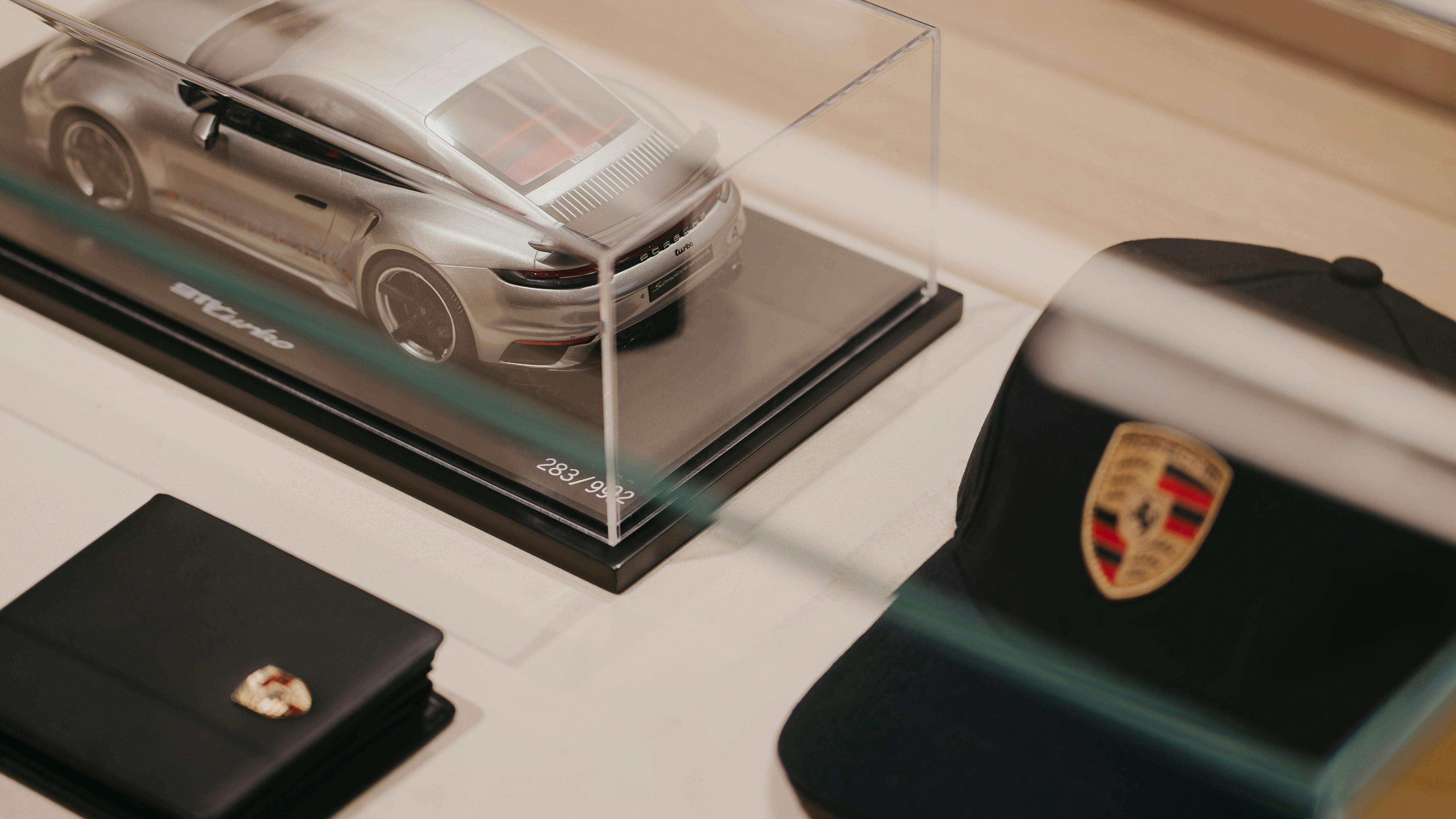 Porsche Model car and cap on display beneath glass case