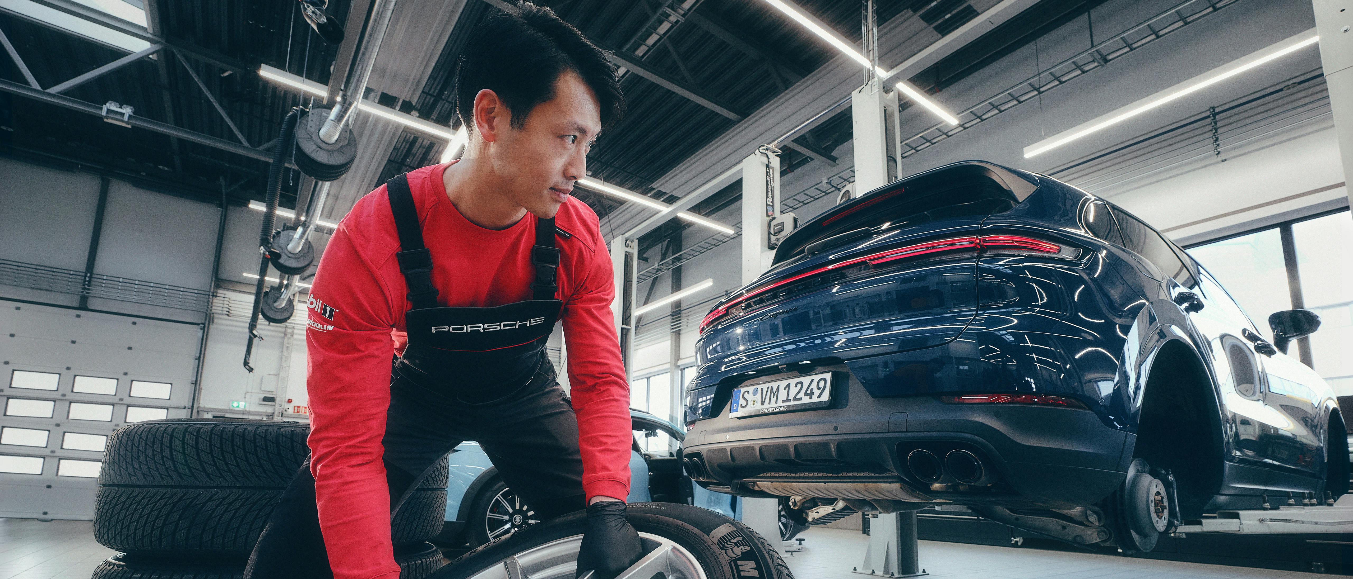 A Porsche workshop employee changes the tyres of a Porsche Cayenne