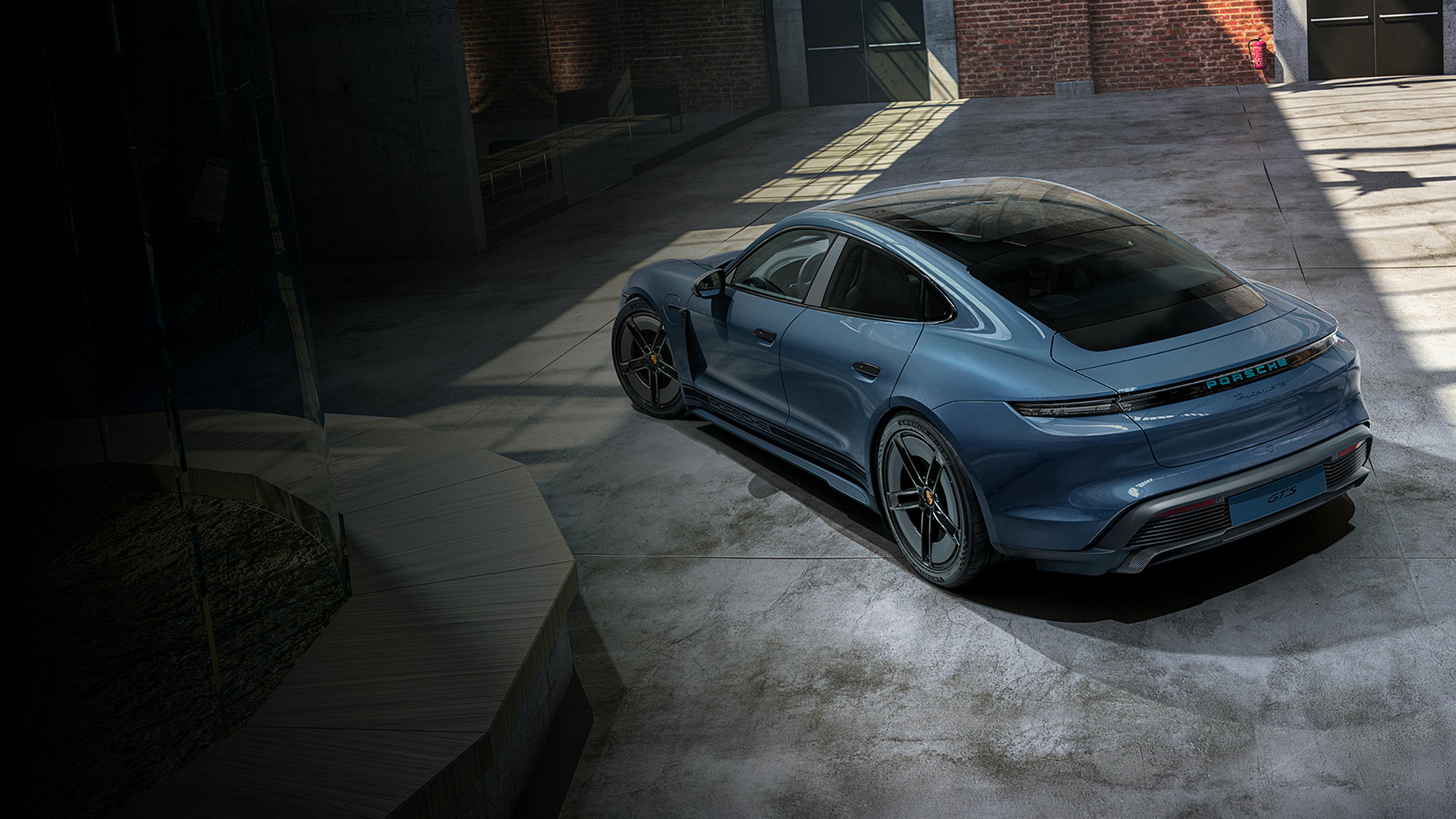 Porsche Exclusive Manufaktur Taycan GTS with SportDesign package Carbon in Pale Blue Metallic. Rear and side view.