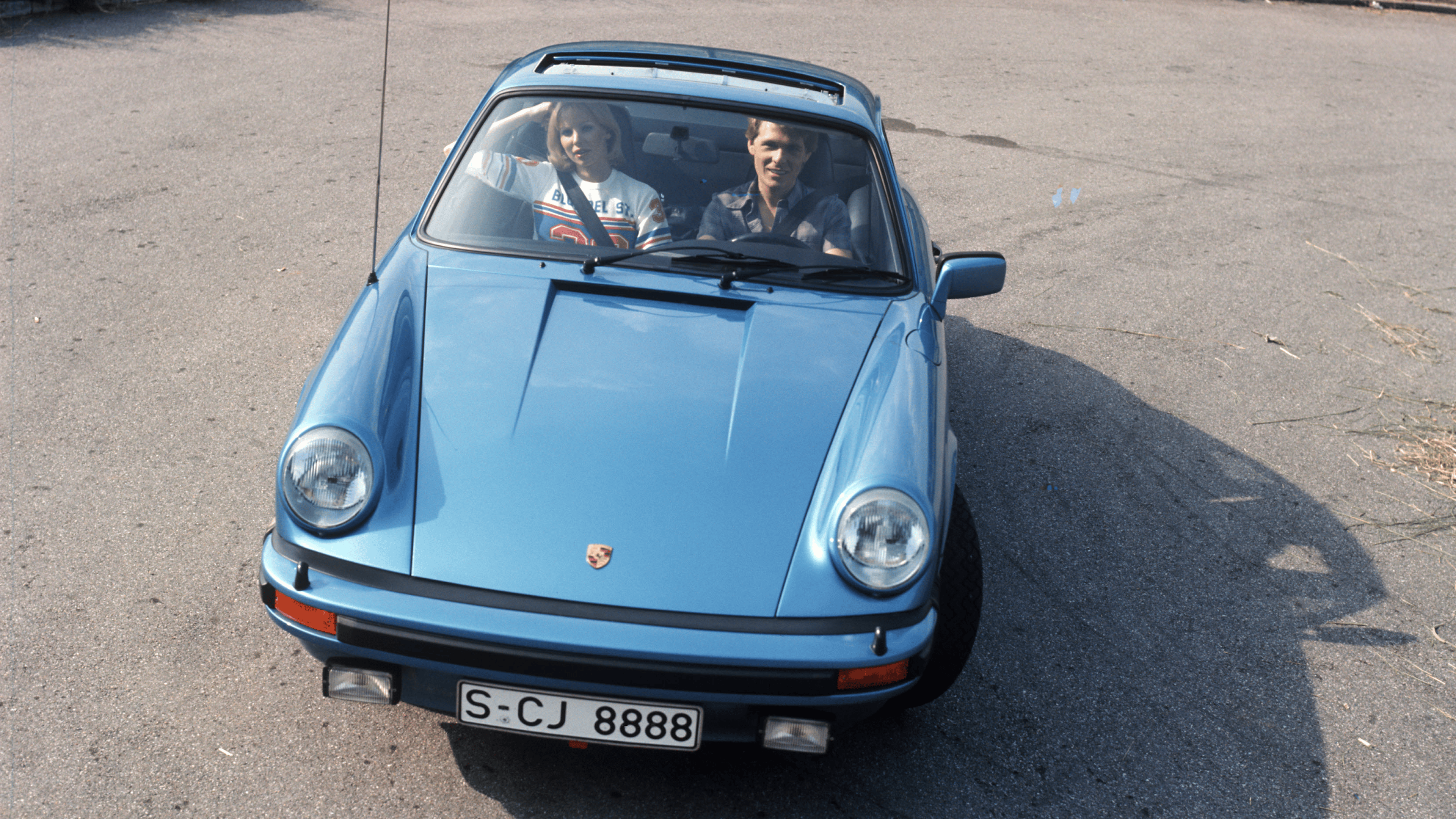 Porsche 911 Carrera 3.0 in blue driving on the street