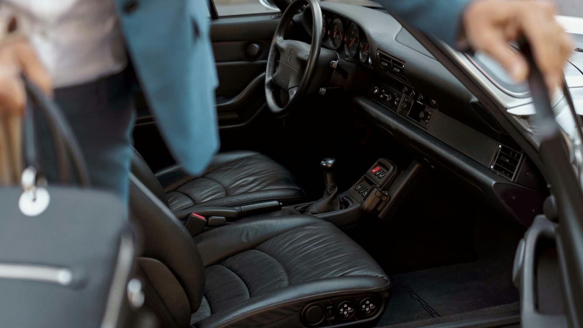 Mann steigt aus einem Fahrzeug mit dunklem Interieur