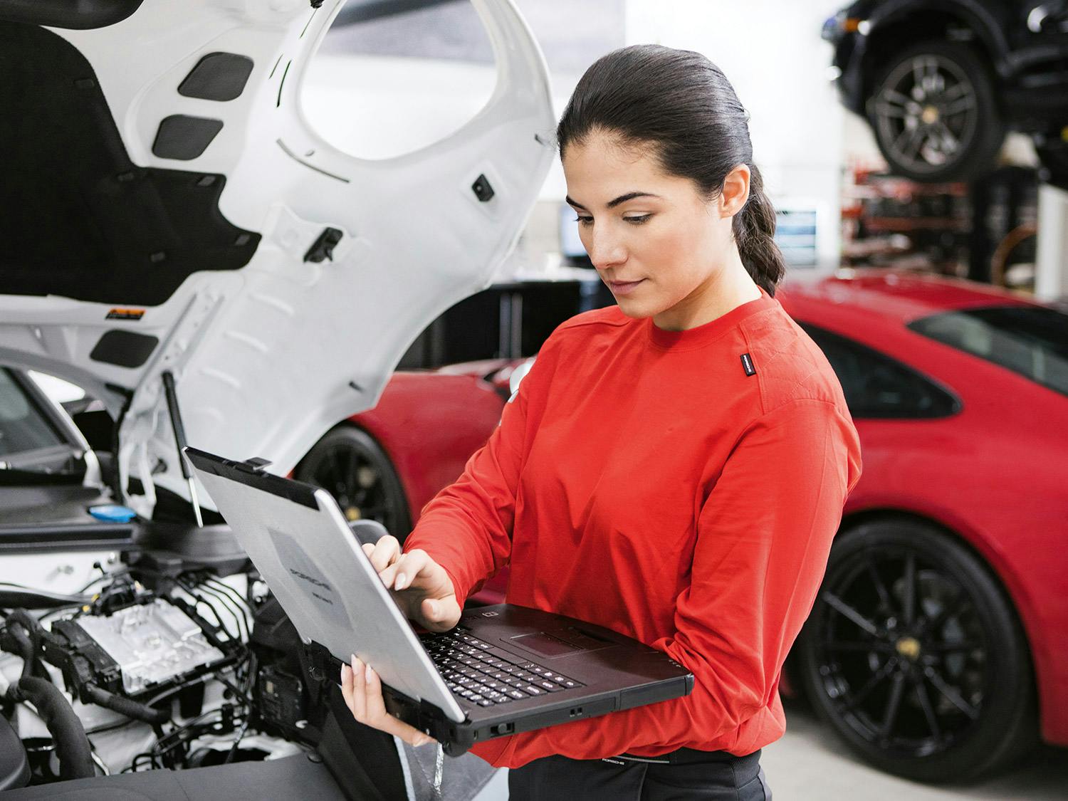 A Porsche employee using a laptop.