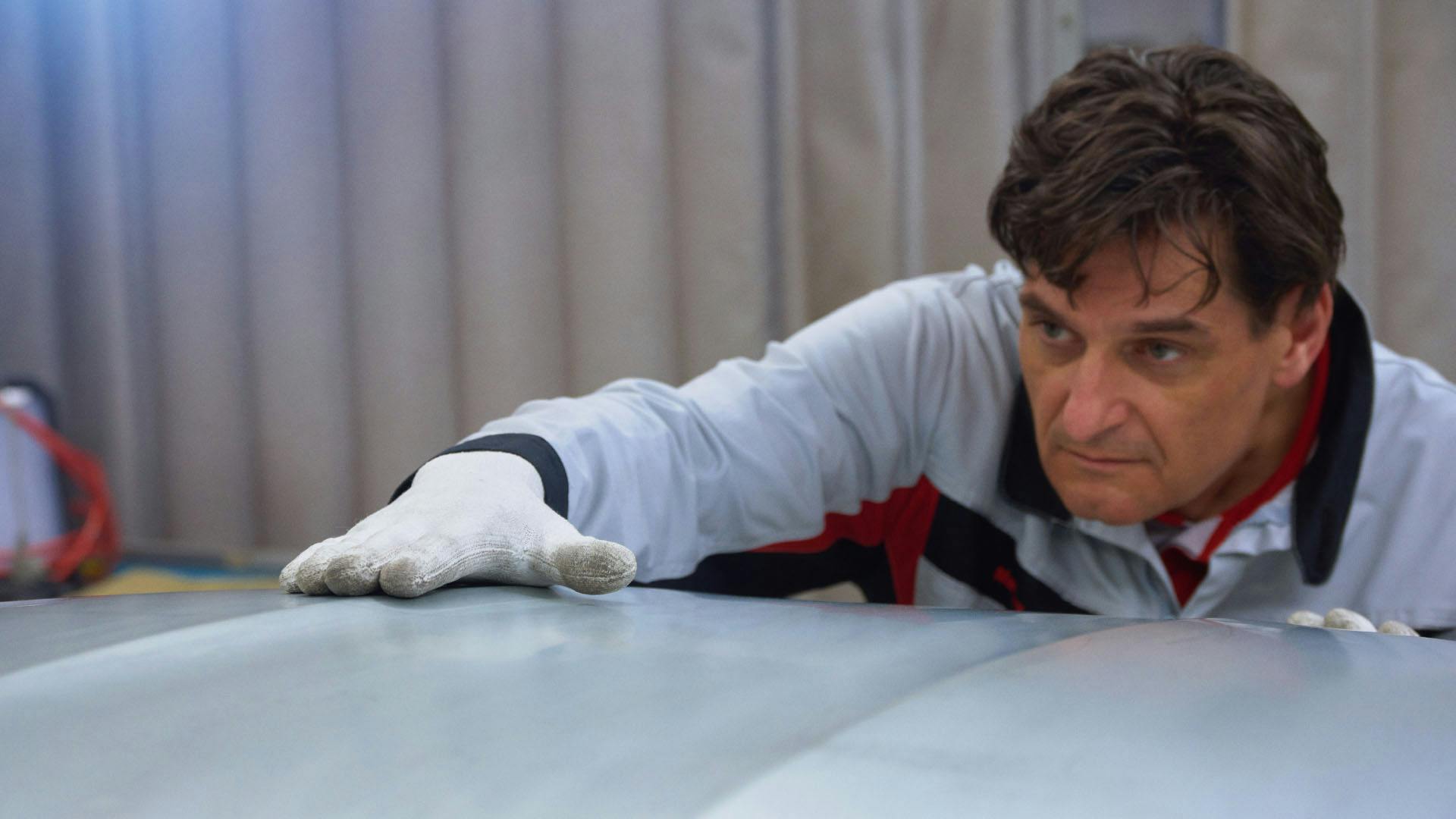 Man with white glove strokes rear lid