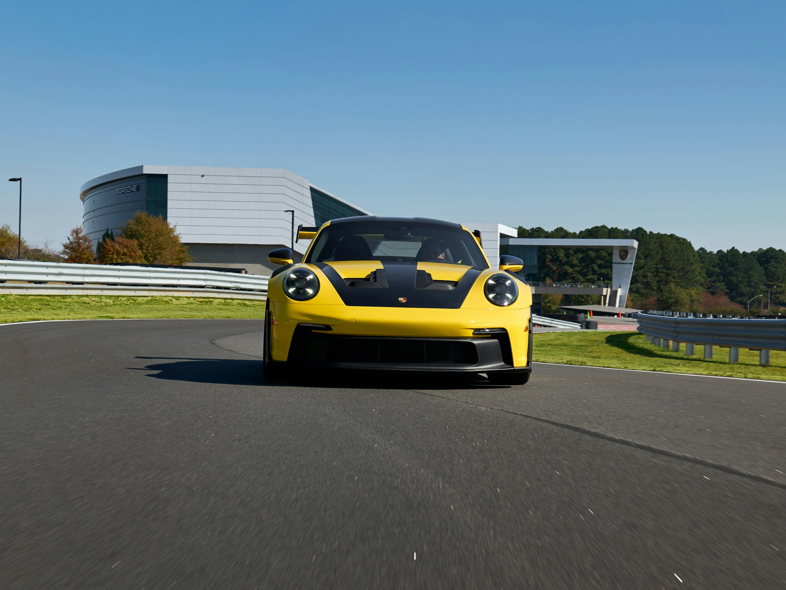 A yellow 911 GT3  drives on a race track.