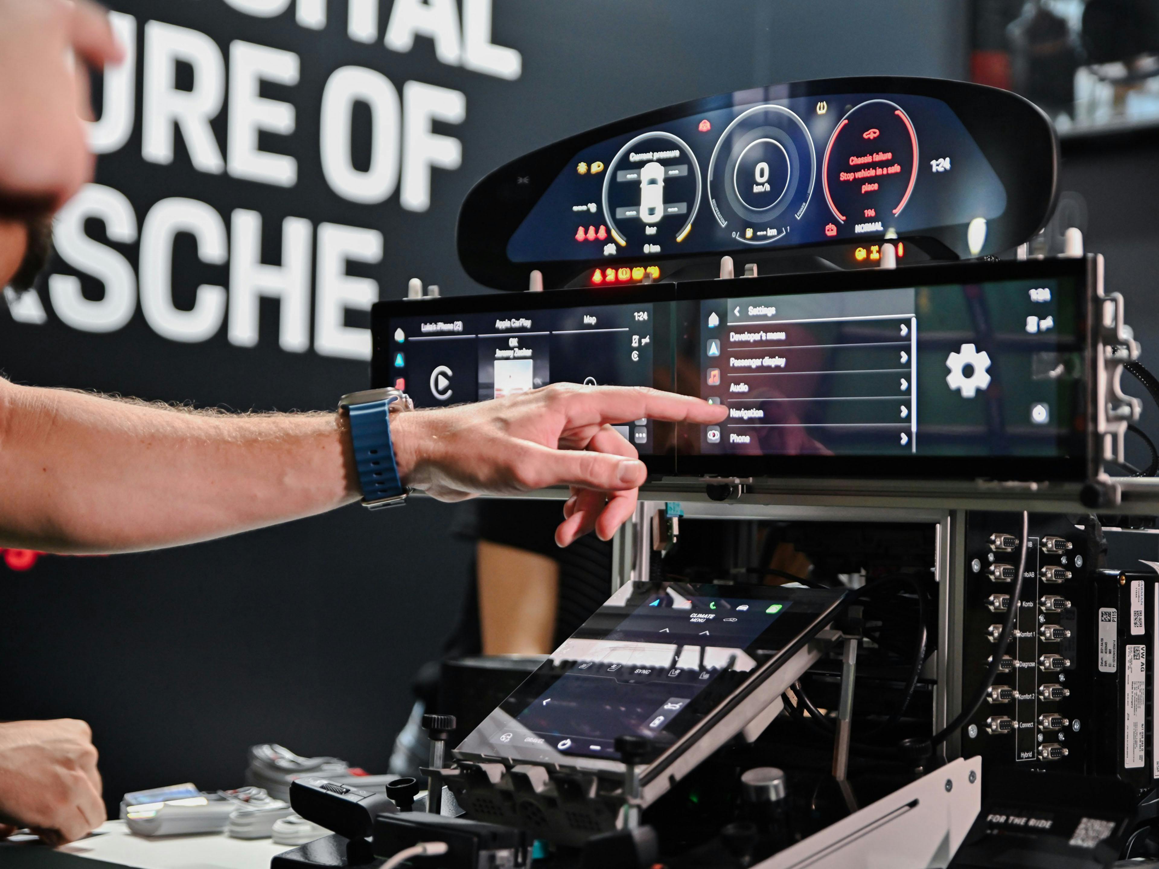 Schwarz-Weiß-Aufnahme: Zwei Porsche Mitarbeiter sitzen gut gelaunt vor einem Monitor.