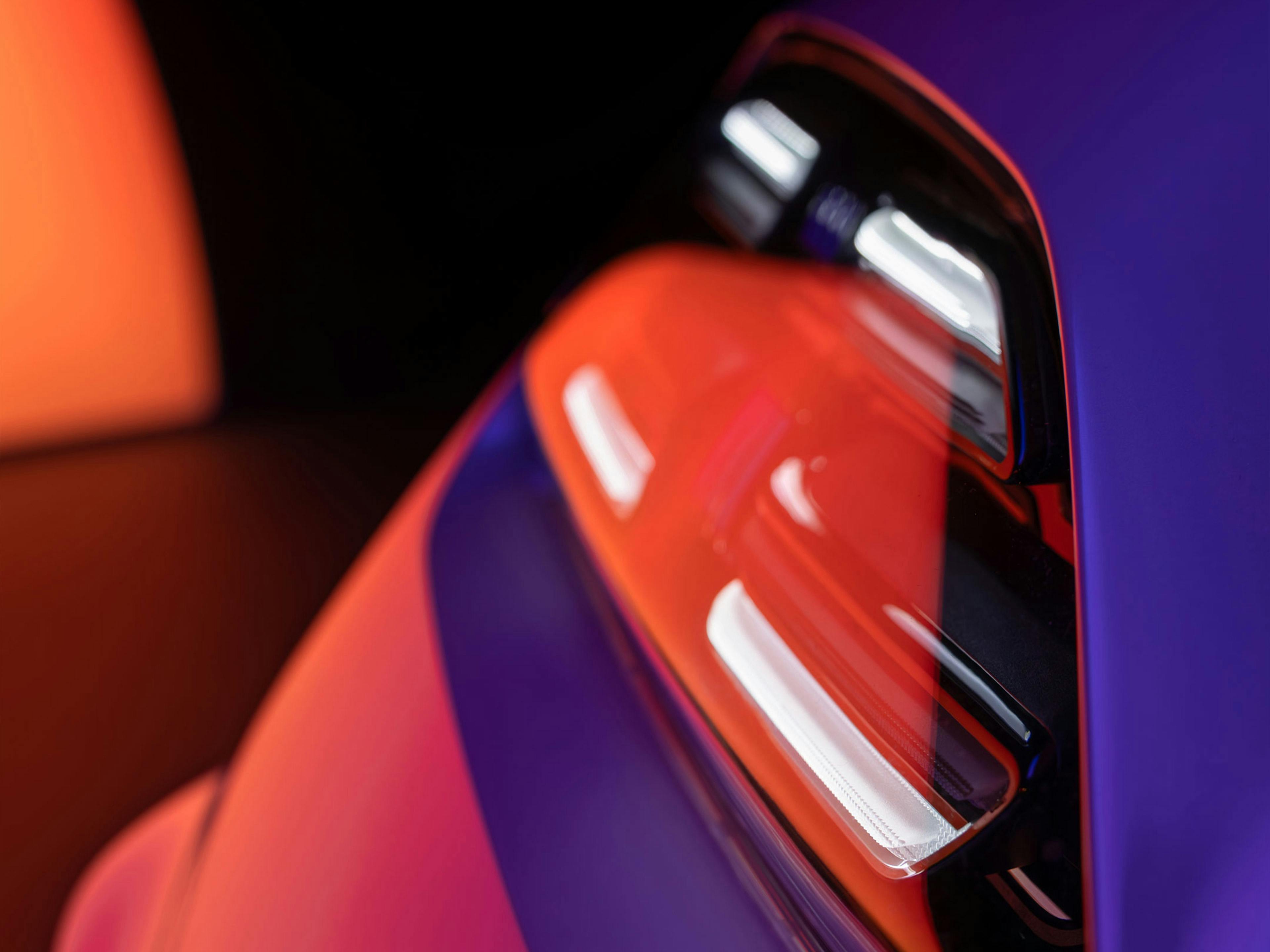 Porsche Macan headlight with vibrant studio lighting.