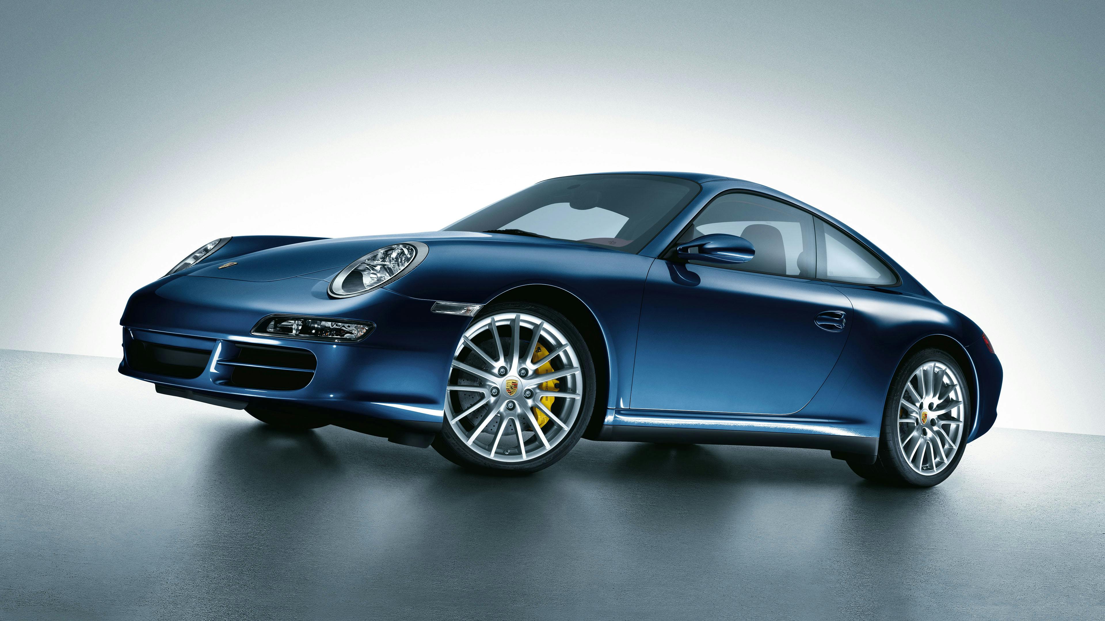 Blue 911 Carrera 4 of type 997 in the studio on a light background.
