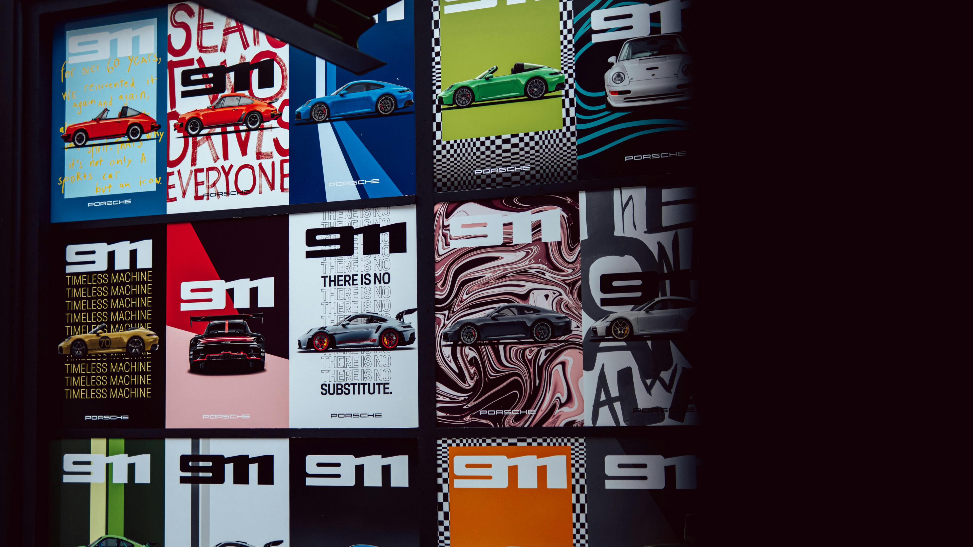 A gallery wall filled with vibrant Porsche posters featuring 911 sports cars with a graphic design background in various colours and styles.