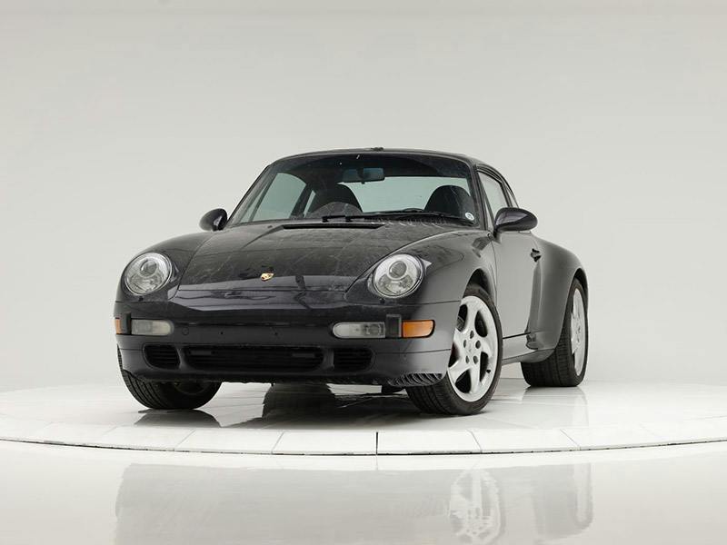 Porsche 993 Carrera 4S stands on a white pedestal.