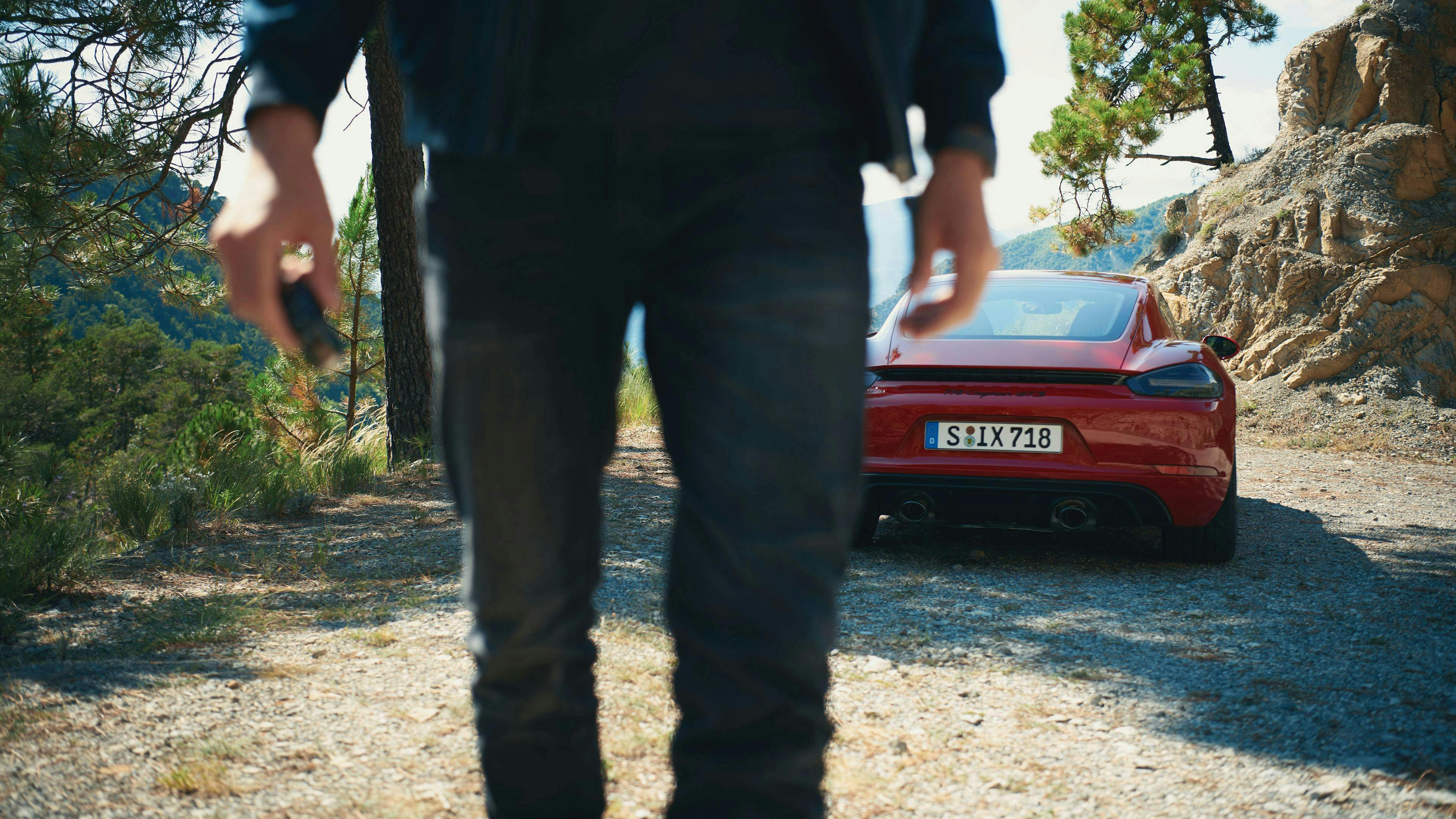 Man holding car keys with a 718 Cayman GTS 4.0 in the background