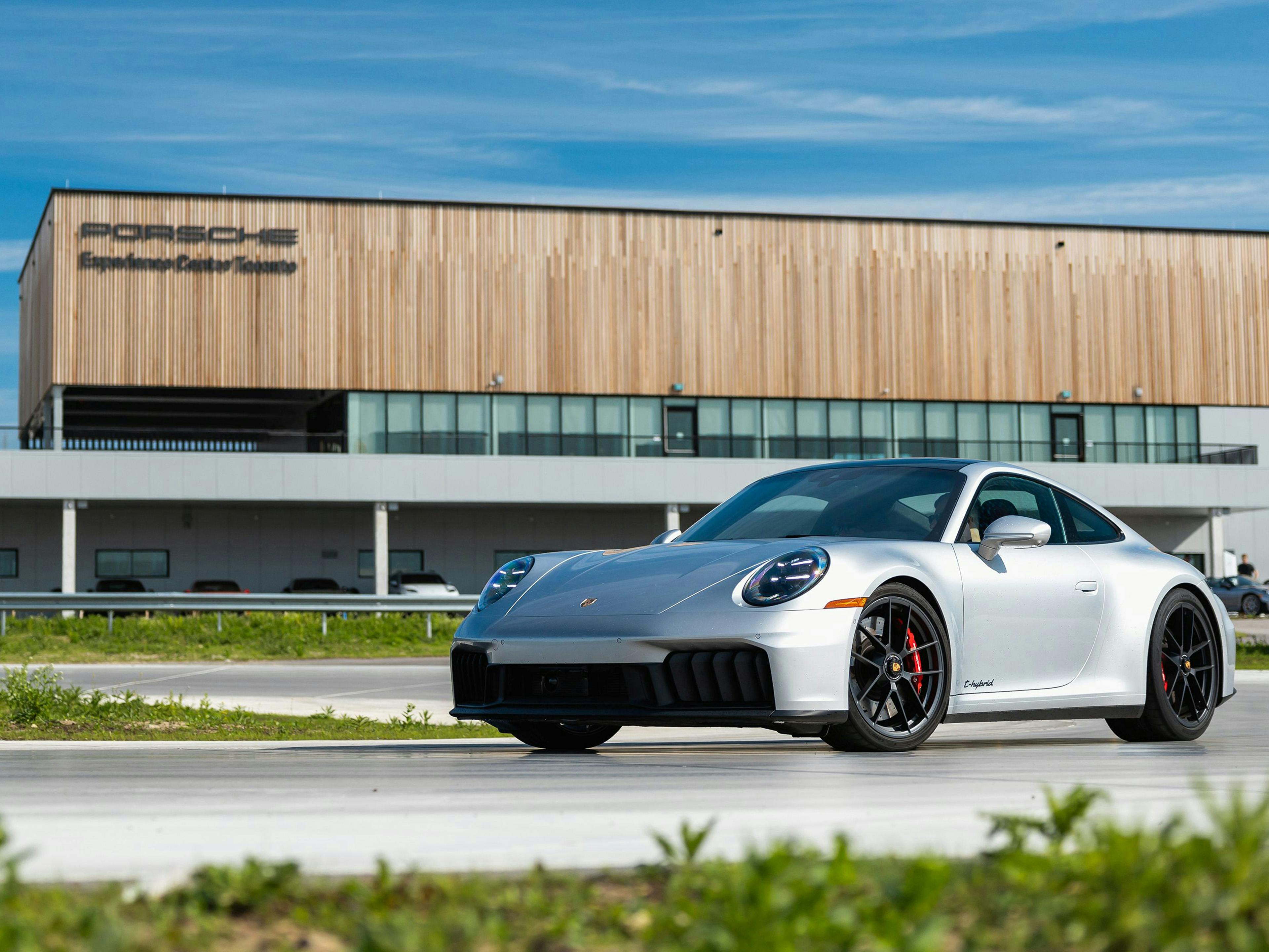 Porsche 911 plateado en la pista de pruebas frente al Porsche Experience Center de Toronto, Canadá.