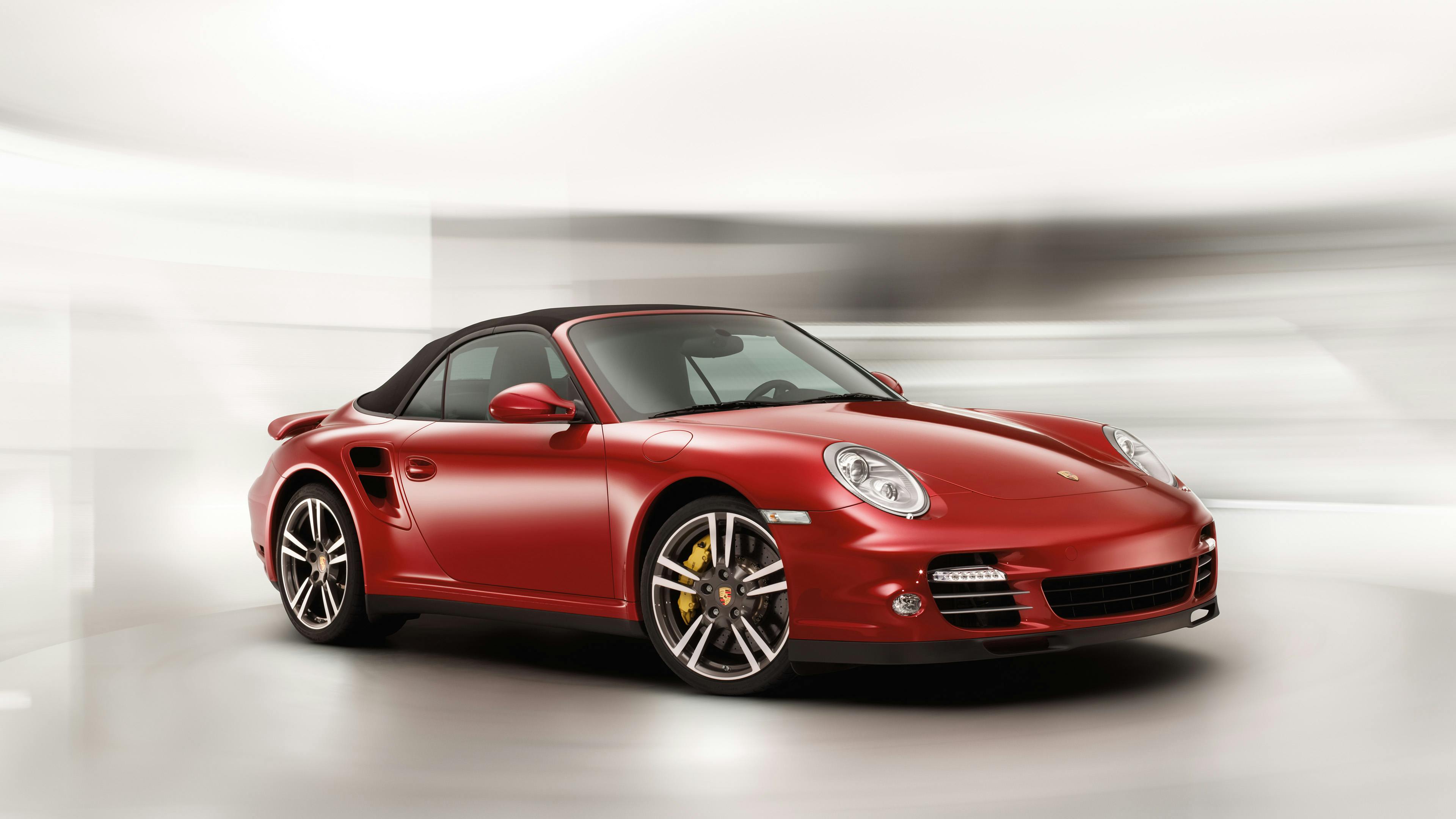 Studio shot of a red 997 911 Turbo Cabriolet on a light background.