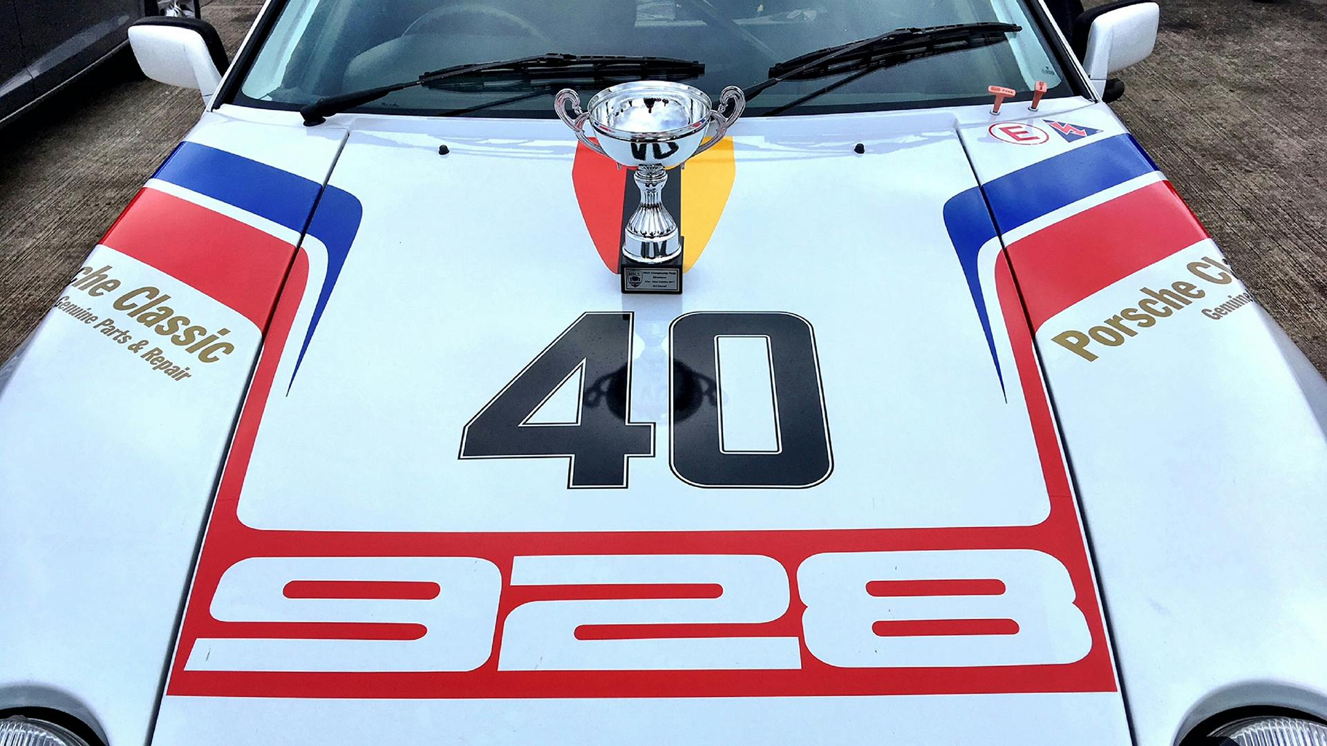 The Silverstone Finals trophy standing on the bonnet of the Porsche 928.
