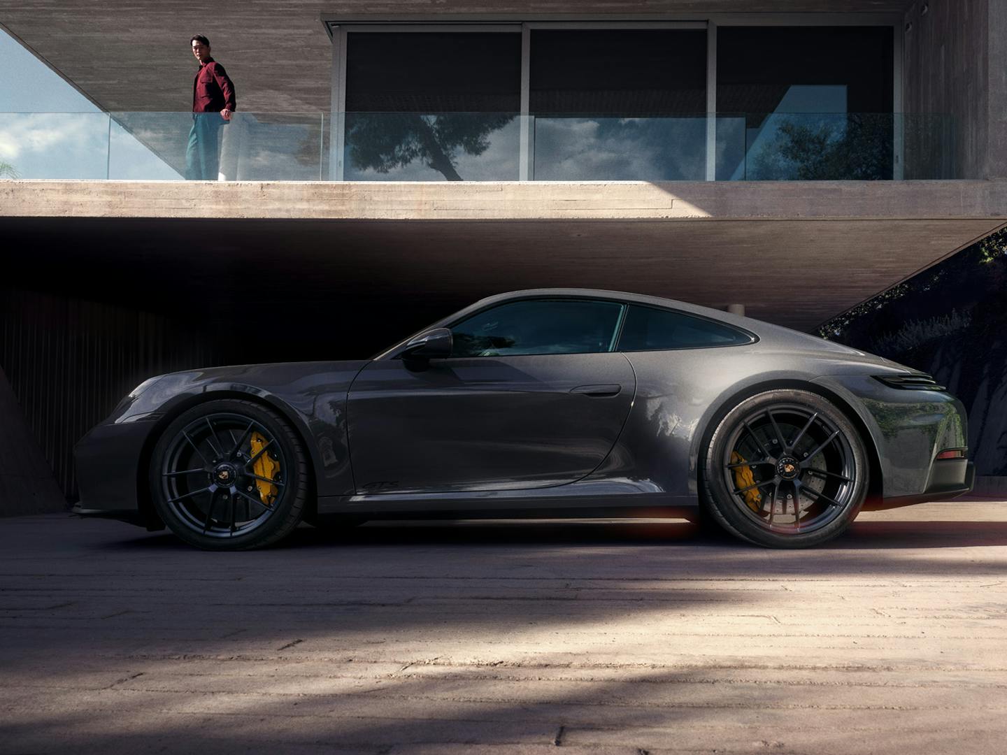 The 911 Carrera GTS in front of a modern house.